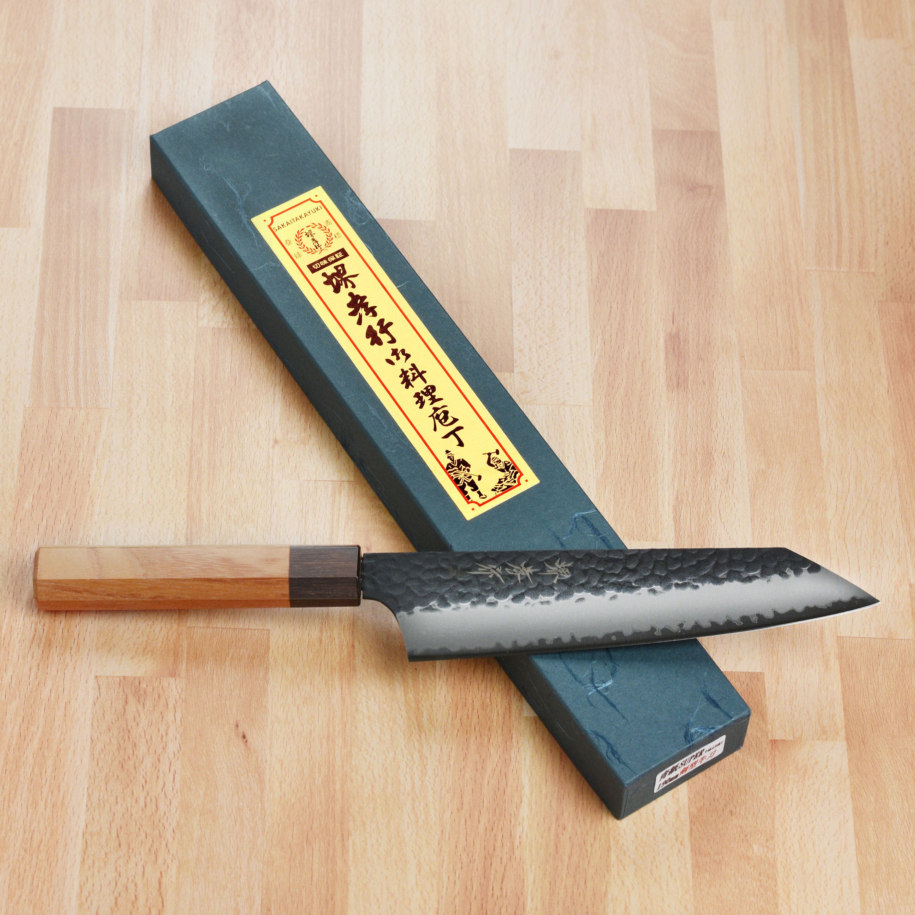 Side view of the Takayuki Aogami Kiritsuke knife highlighting the hammered finish and sharp edge.