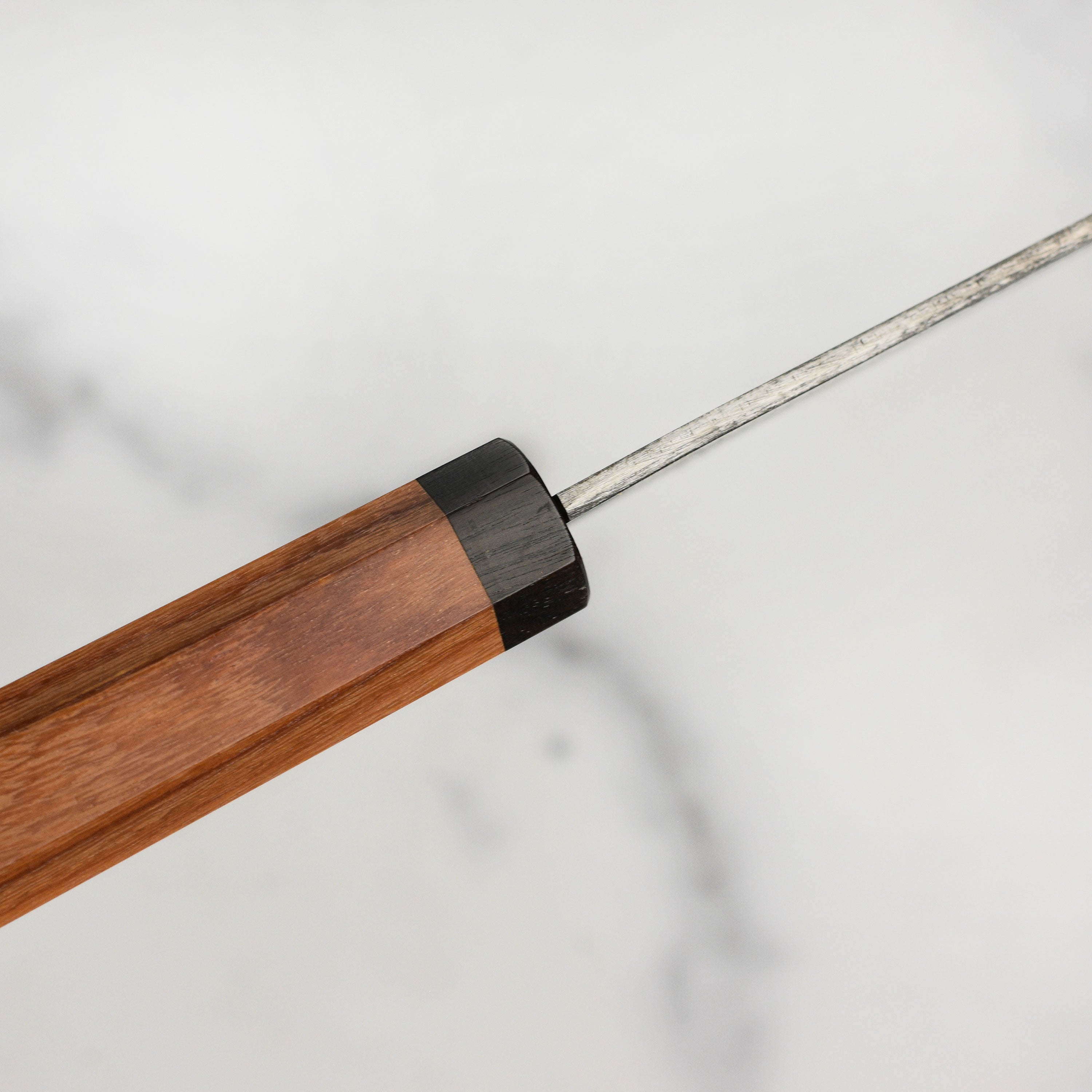 Close-up of Takayuki Tokujo Shirogami Bunka knife blade highlighting its sharp edge and kurouchi finish.