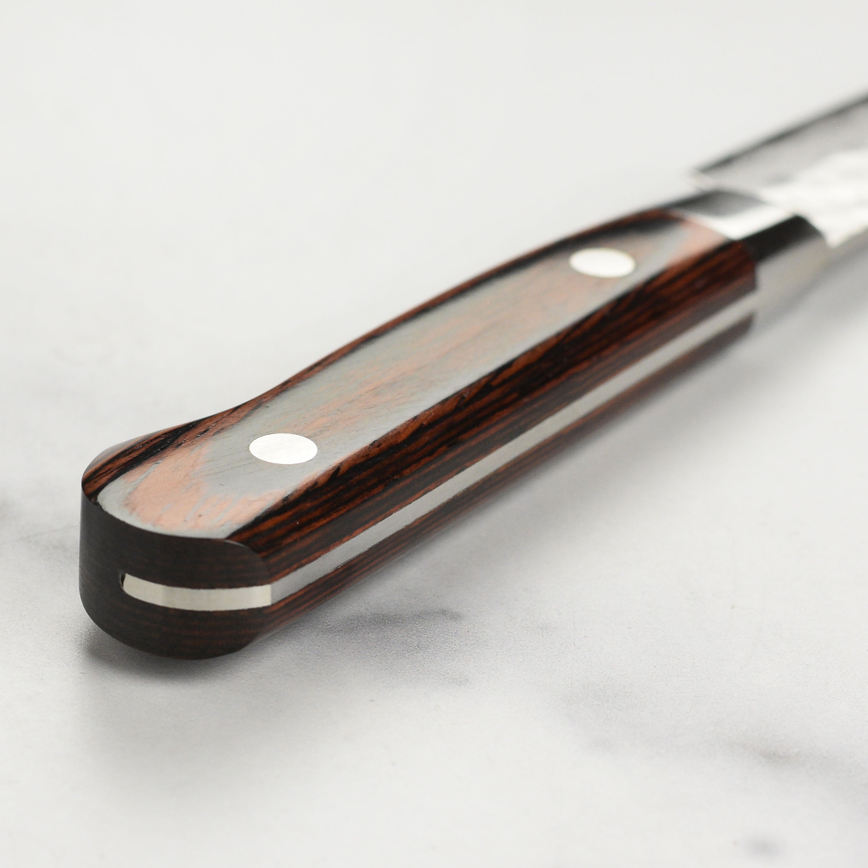 Close-up of Takayuki Damascus knife showing detailed craftsmanship and blade edge