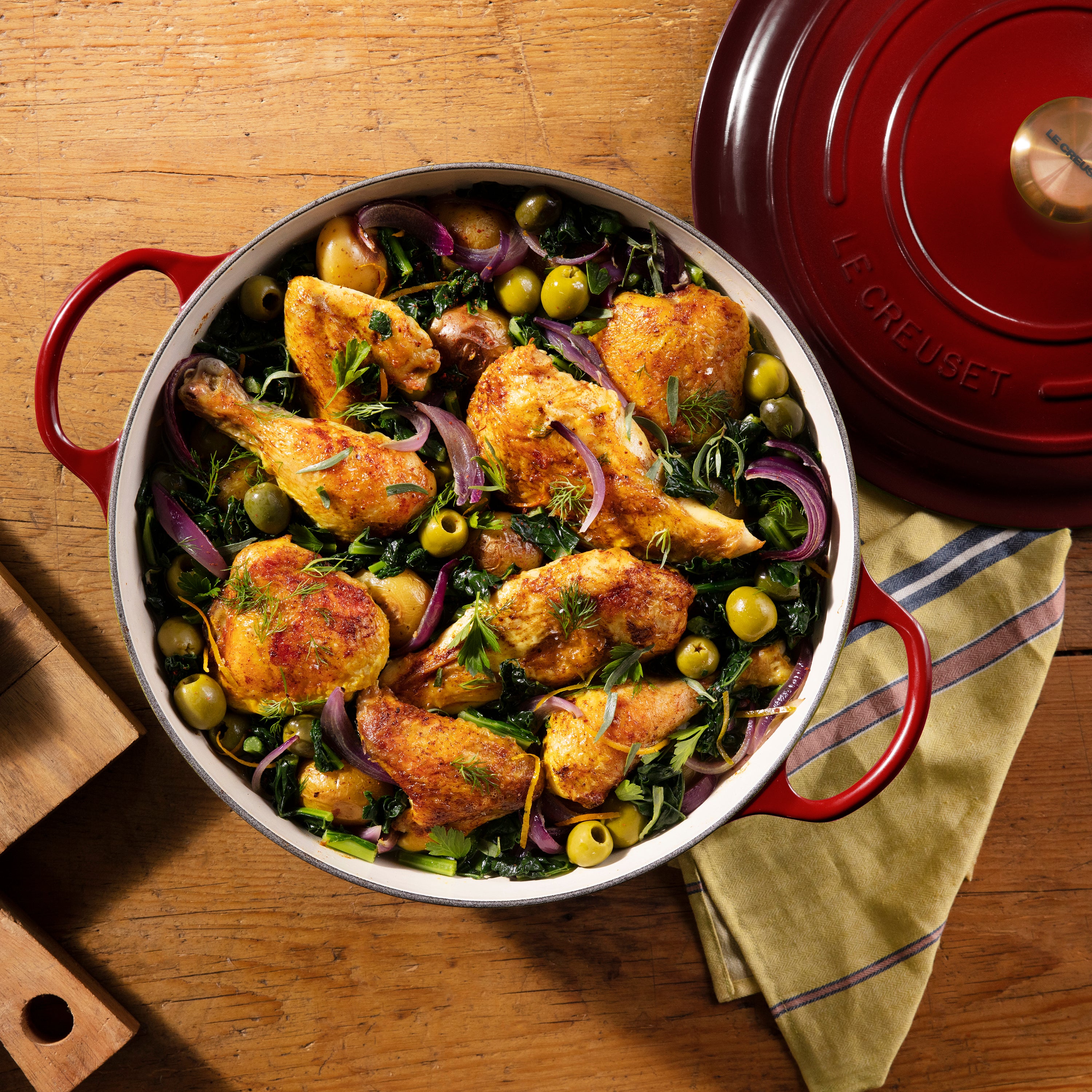 Close-up of the gold stainless steel knob on the Le Creuset cast iron oven, emphasizing its stylish and functional features.