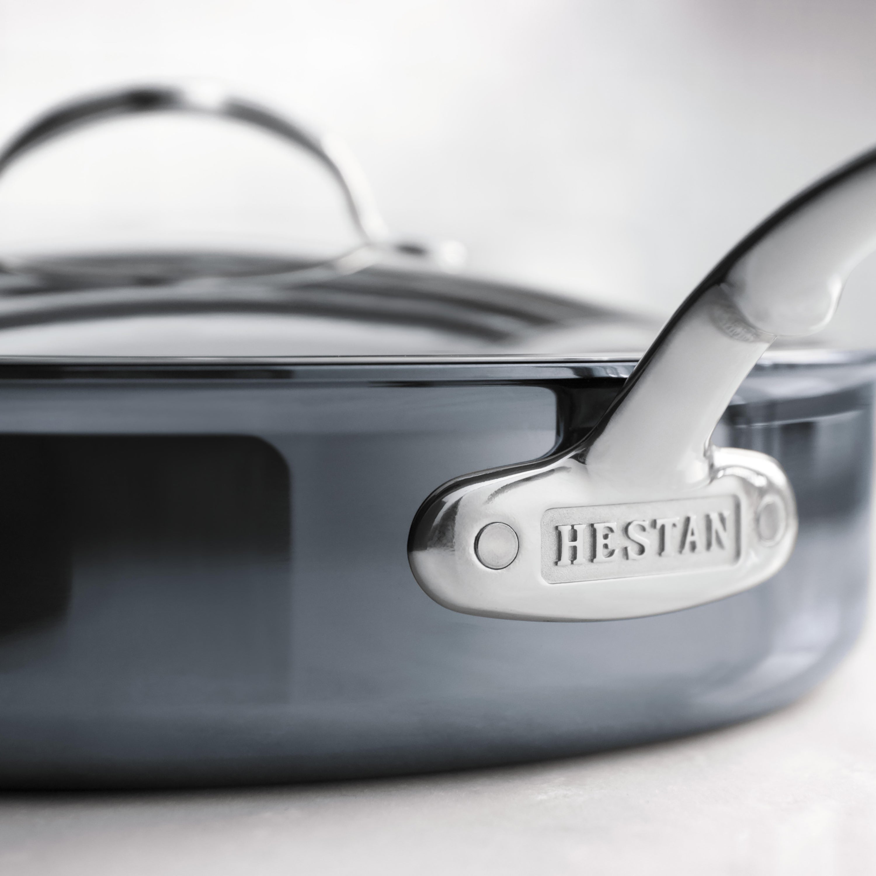 Hestan skillet lid placed on a sauté pan in a kitchen setting, highlighting its versatility and modern aesthetic.