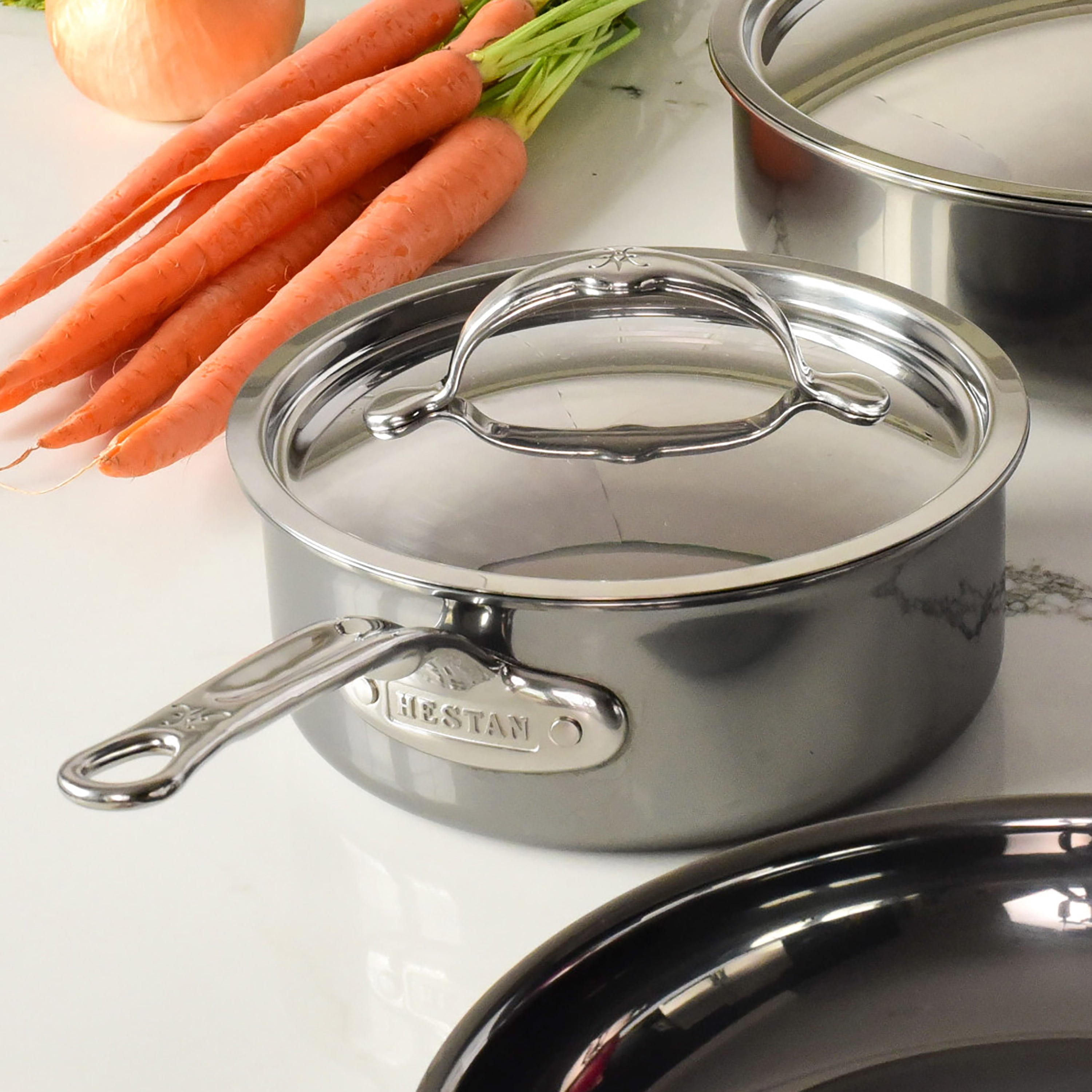 Lifestyle shot of Hestan cookware with the 8.5" stainless steel lid, highlighting its compatibility with induction cooking.