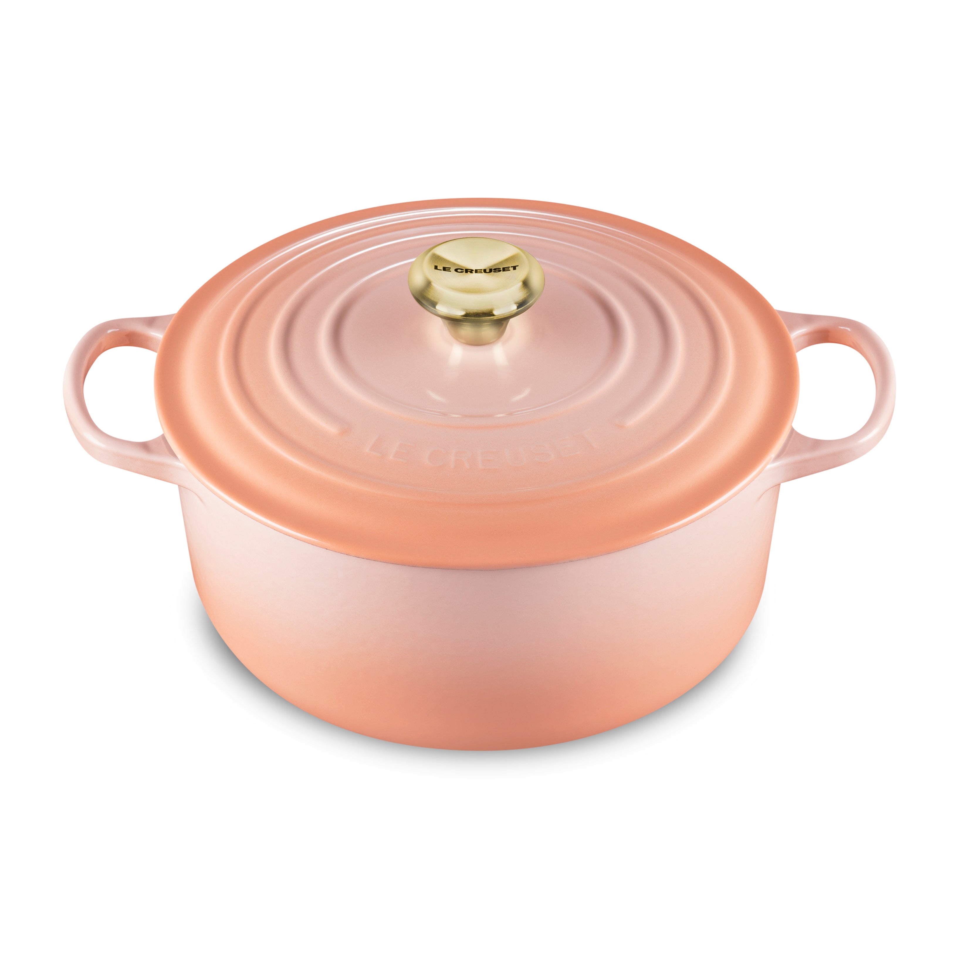 Le Creuset 7.25-quart enameled Dutch oven in peach color, showcasing its elegant design and ergonomic handles.