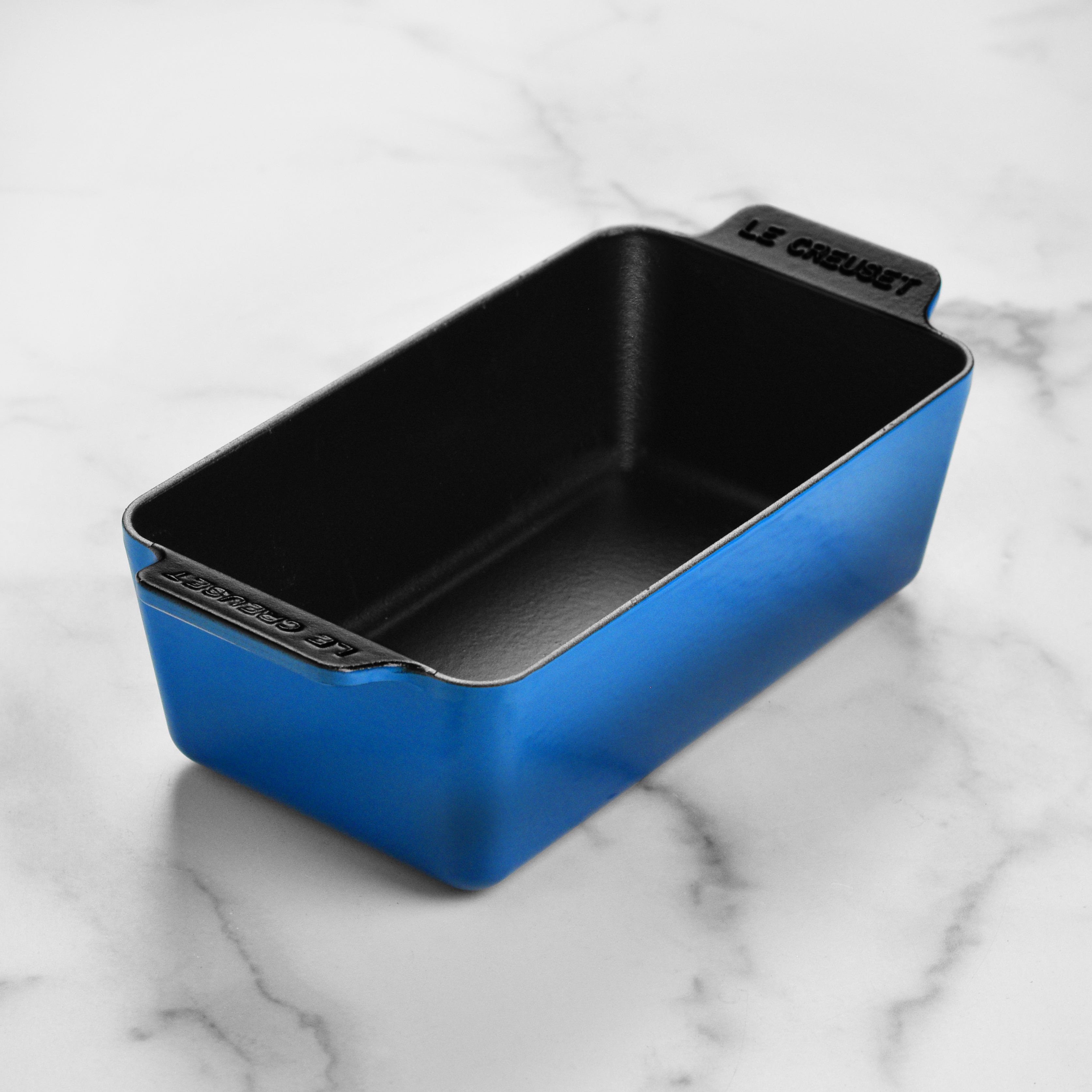 Le Creuset Signature Cast Iron Loaf Pan on a baking countertop, showcasing its durable enamel finish