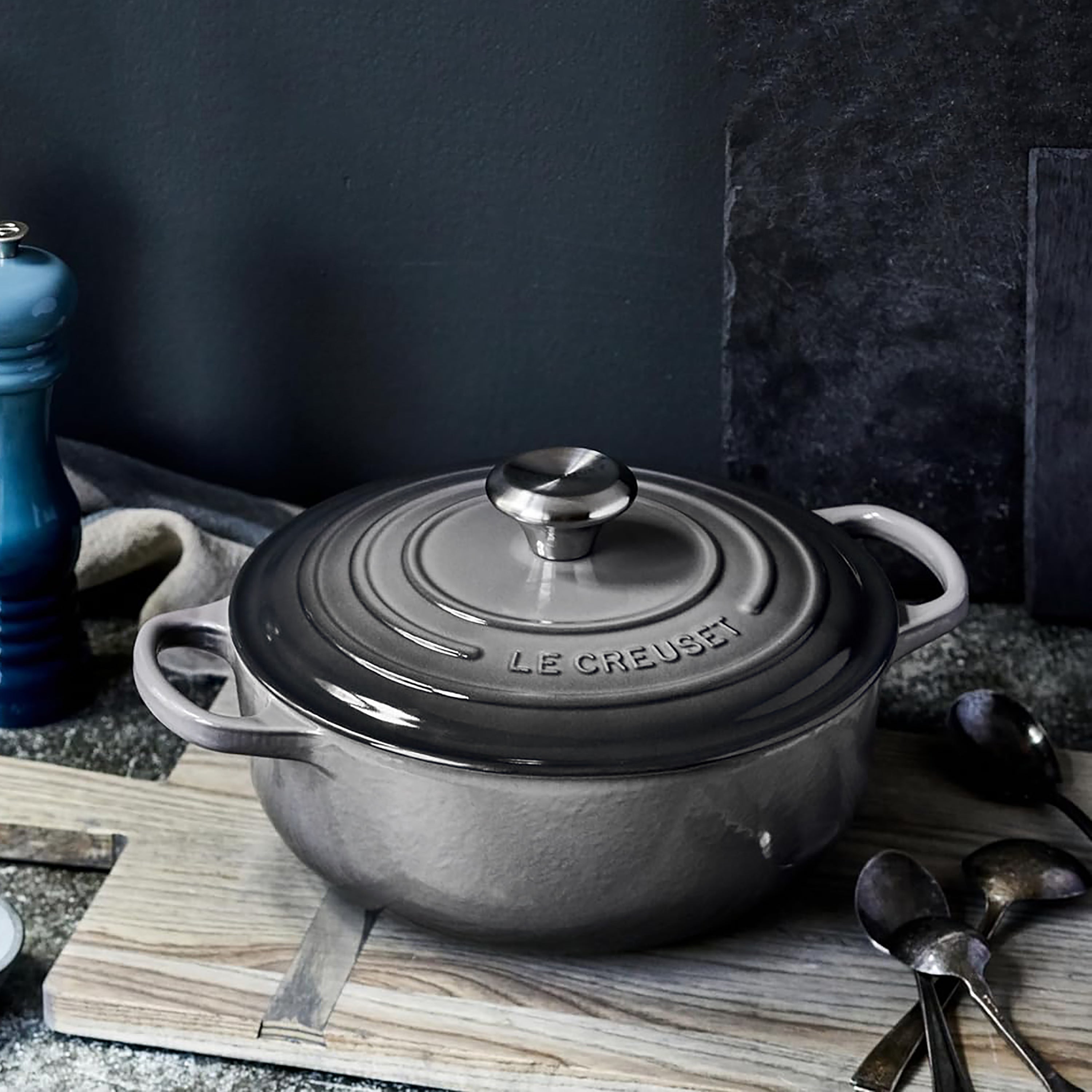 Side angle showing cast iron texture and stainless steel knob, compatible with induction cooktops