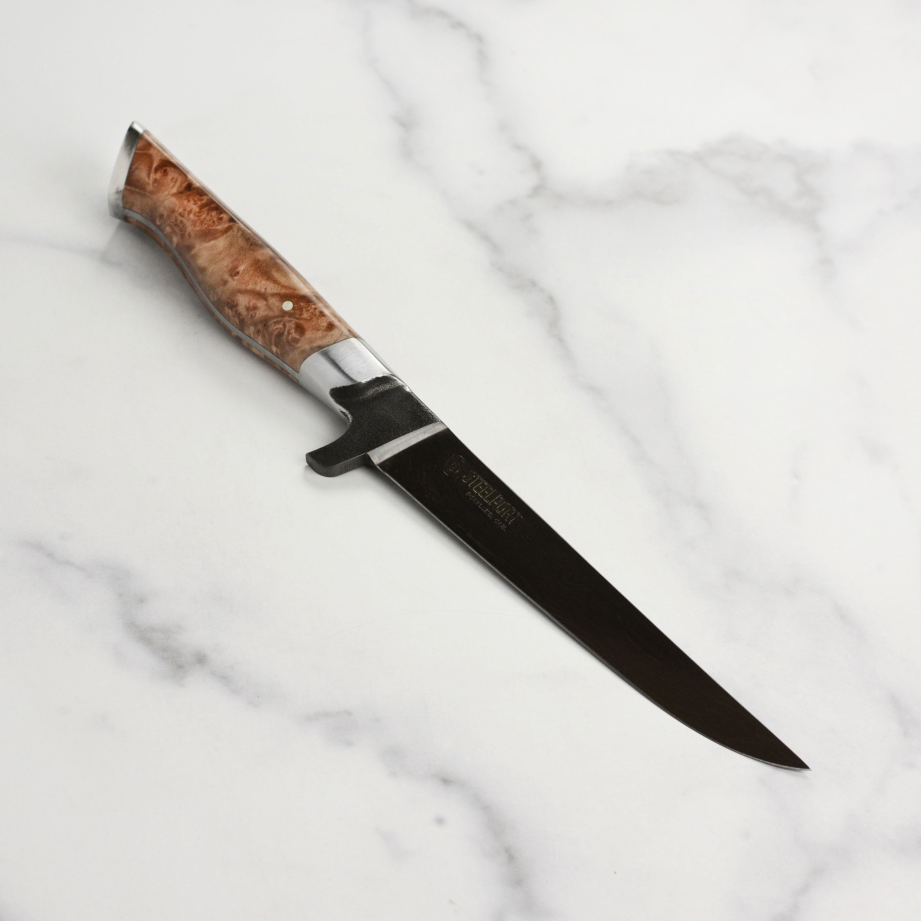 Close-up of the engraved Steelport logo on the knifes end cap, highlighting craftsmanship.