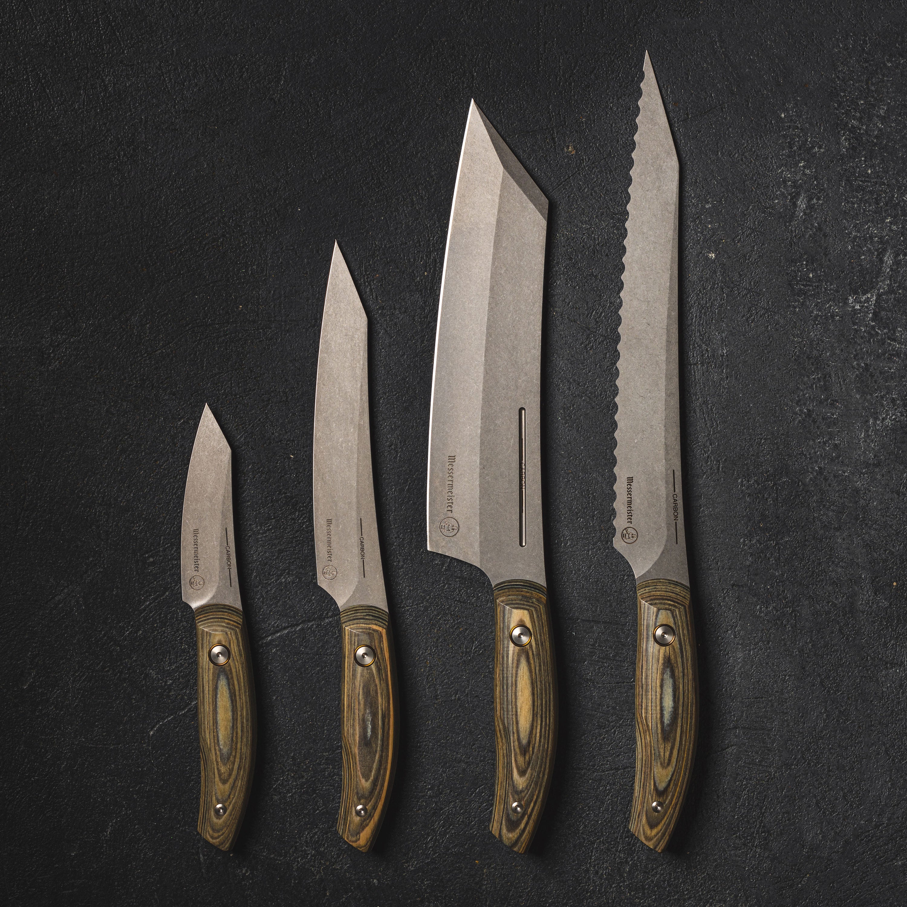 Messermeister 5-piece carbon steel knife set displayed on a wooden cutting board.