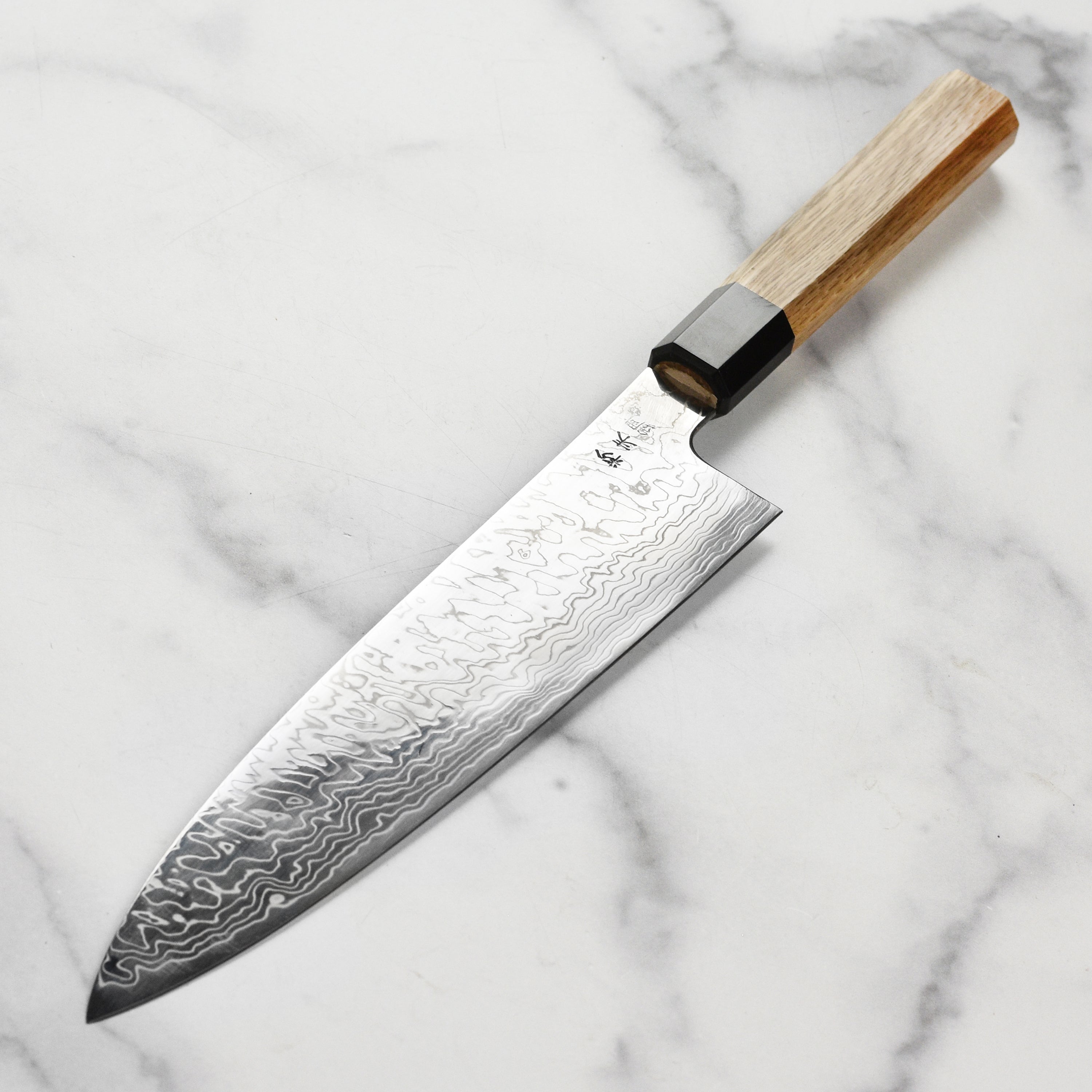 Close-up of the Damascus pattern on the Sukenari SG2 knife, showcasing its unique craftsmanship.