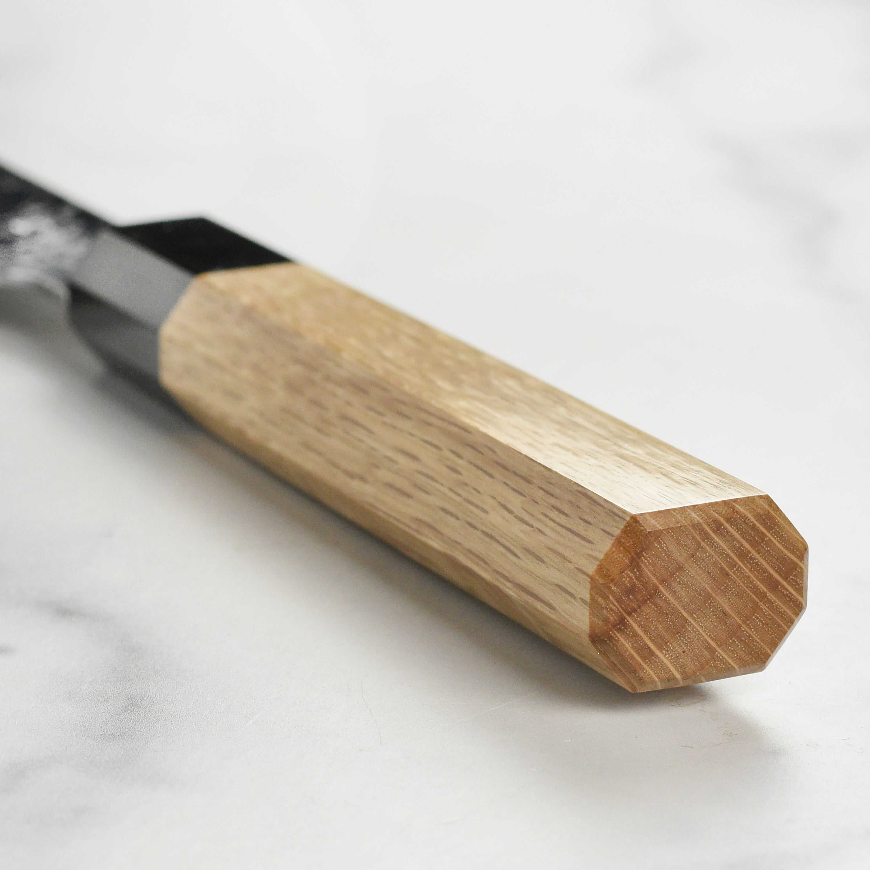 Close-up of the Sukenari SG2 Damascus knife cutting fresh vegetables.