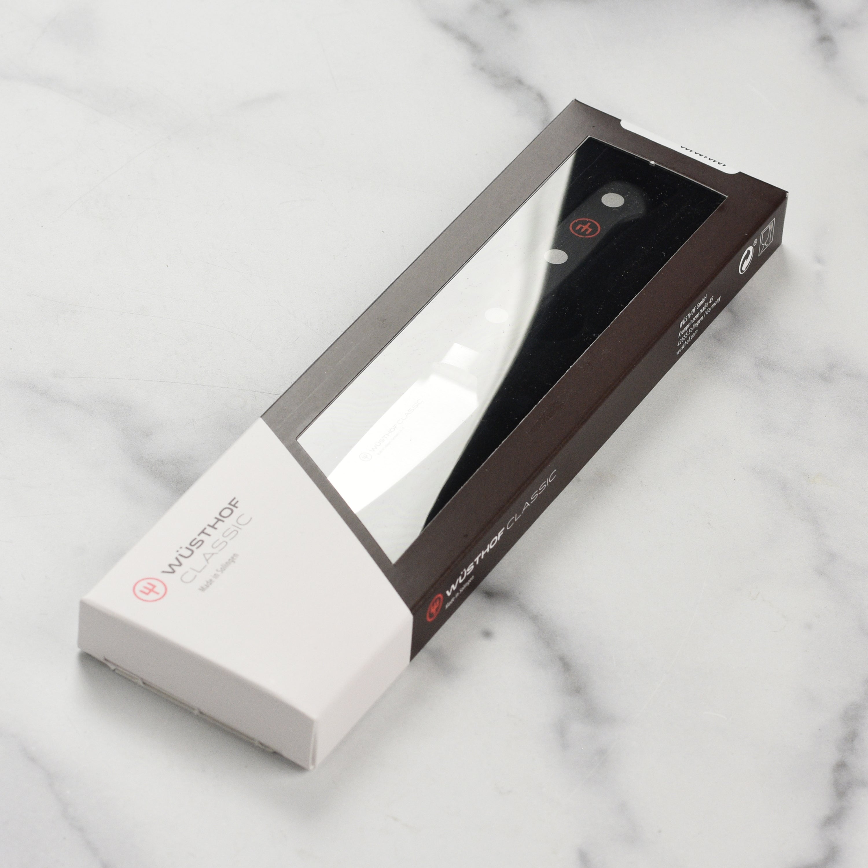 Wusthof Classic 3.5 inch paring knife displayed on a wooden cutting board, emphasizing its sleek design.