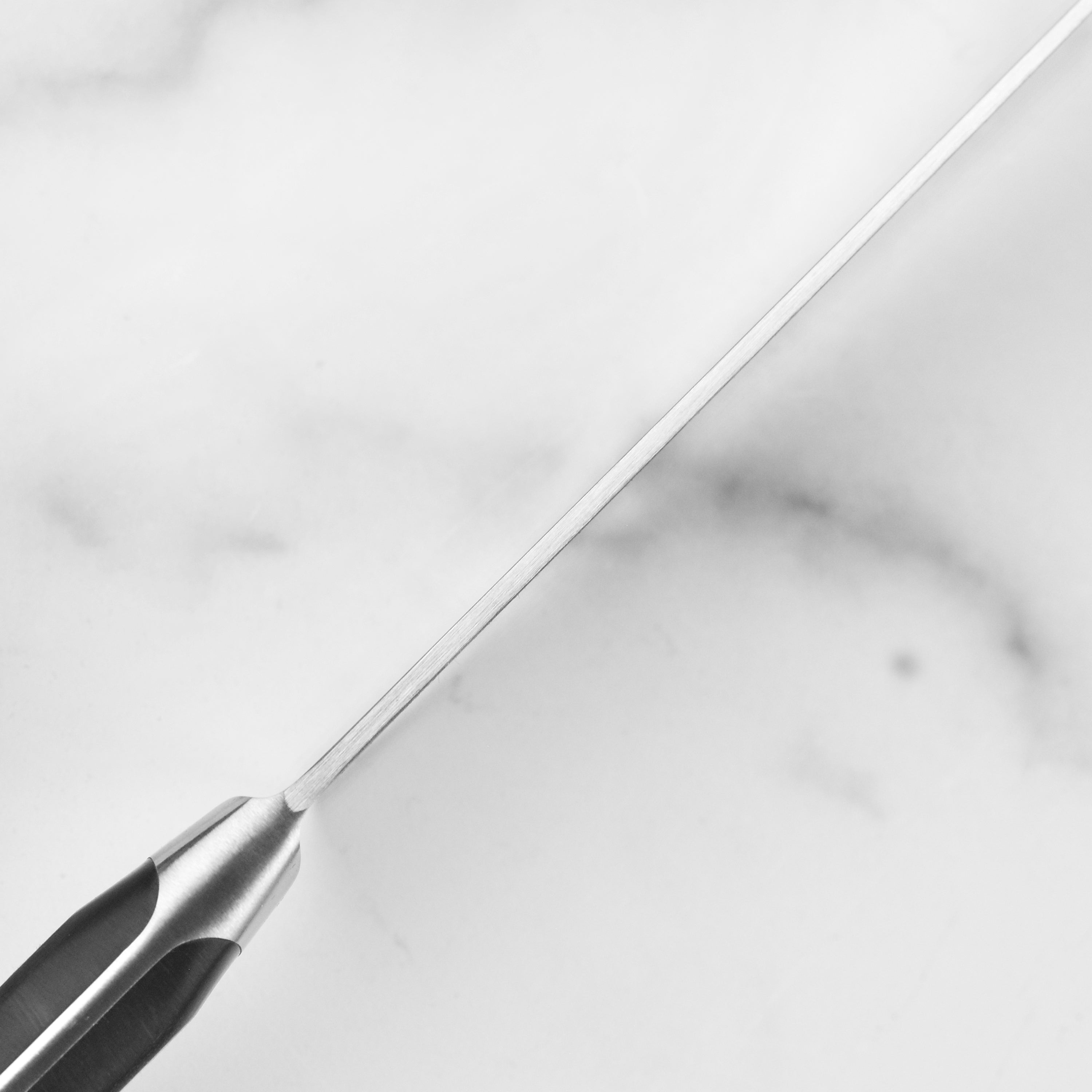 Wusthof Classic 6-Inch Chefs Knife displayed with a cutting board and fresh ingredients.