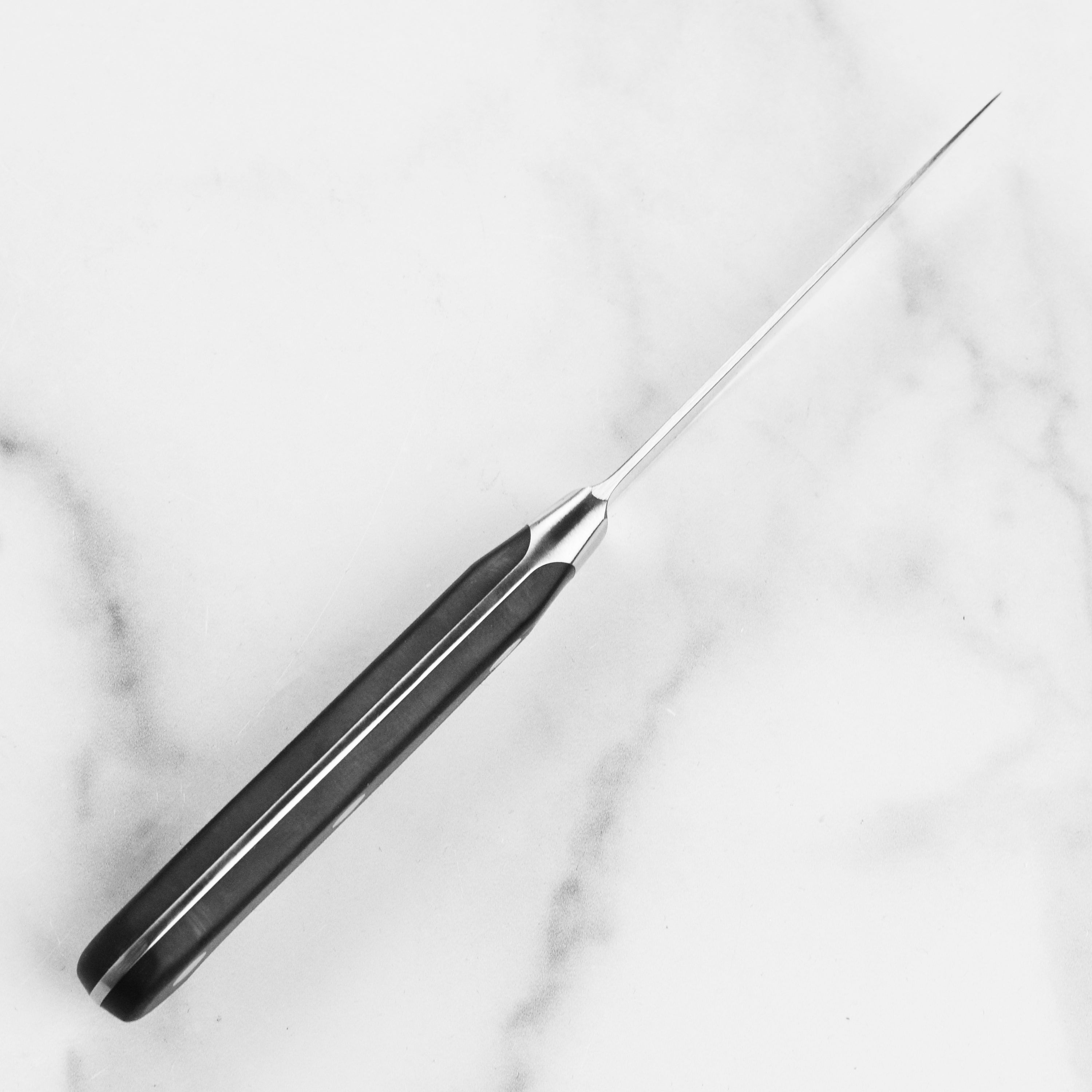 Wusthof Classic 3.5 inch paring knife displayed on a wooden cutting board, emphasizing its sleek design.