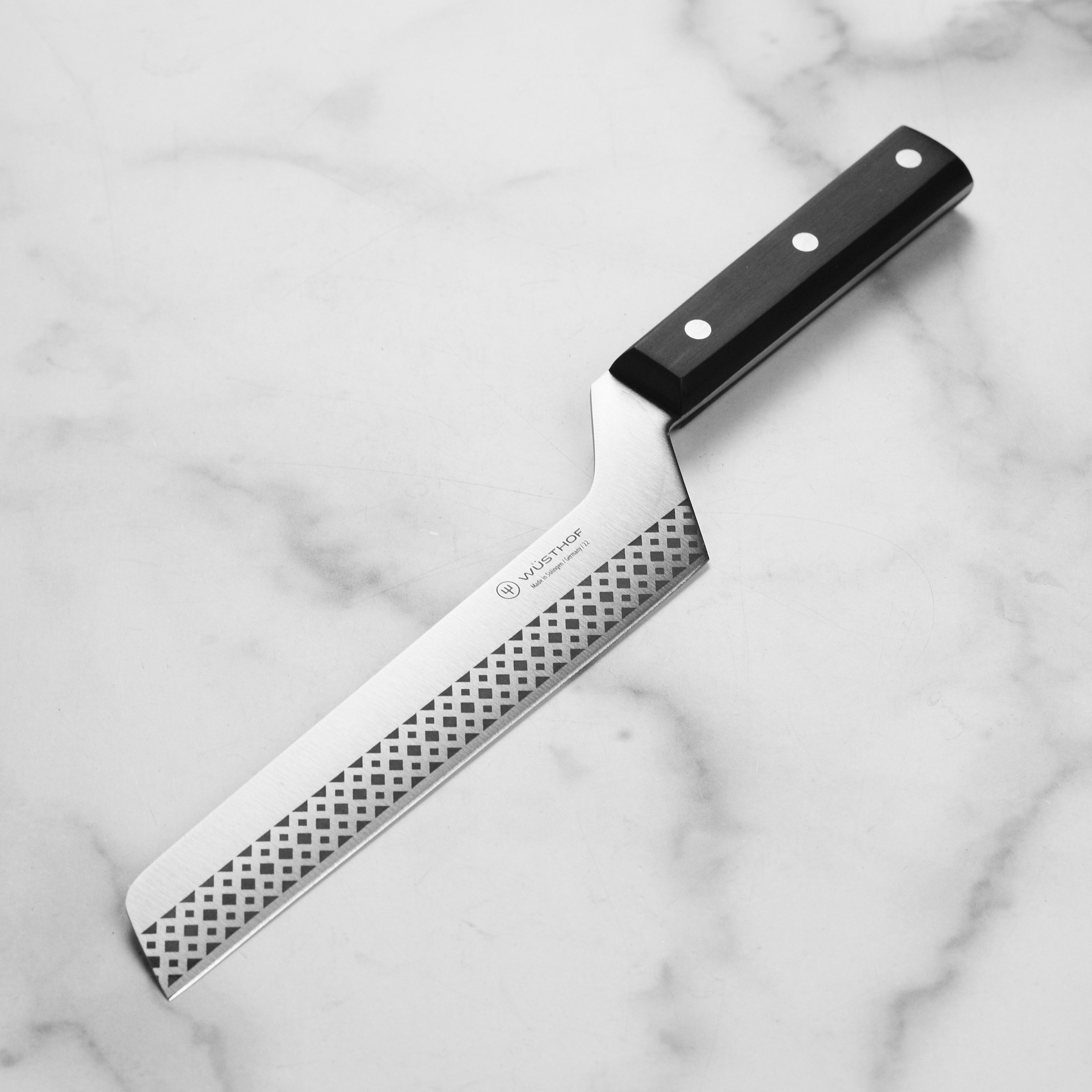Premium German cheese knife showcasing its sharp edge and ergonomic handle.