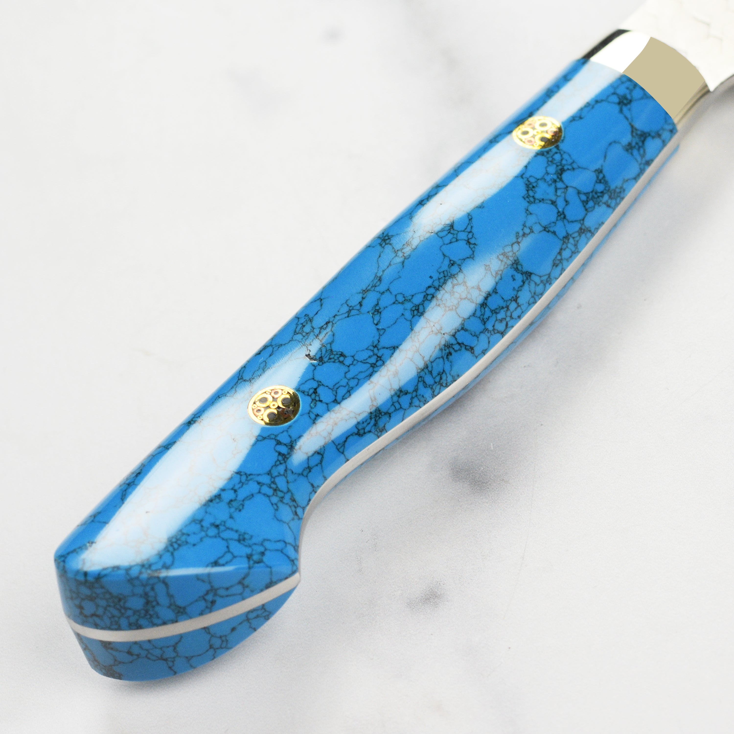 Side view of the Nigara SG2 Migaki Tsuchime 7" Bunka Knife with blue turquoise handle