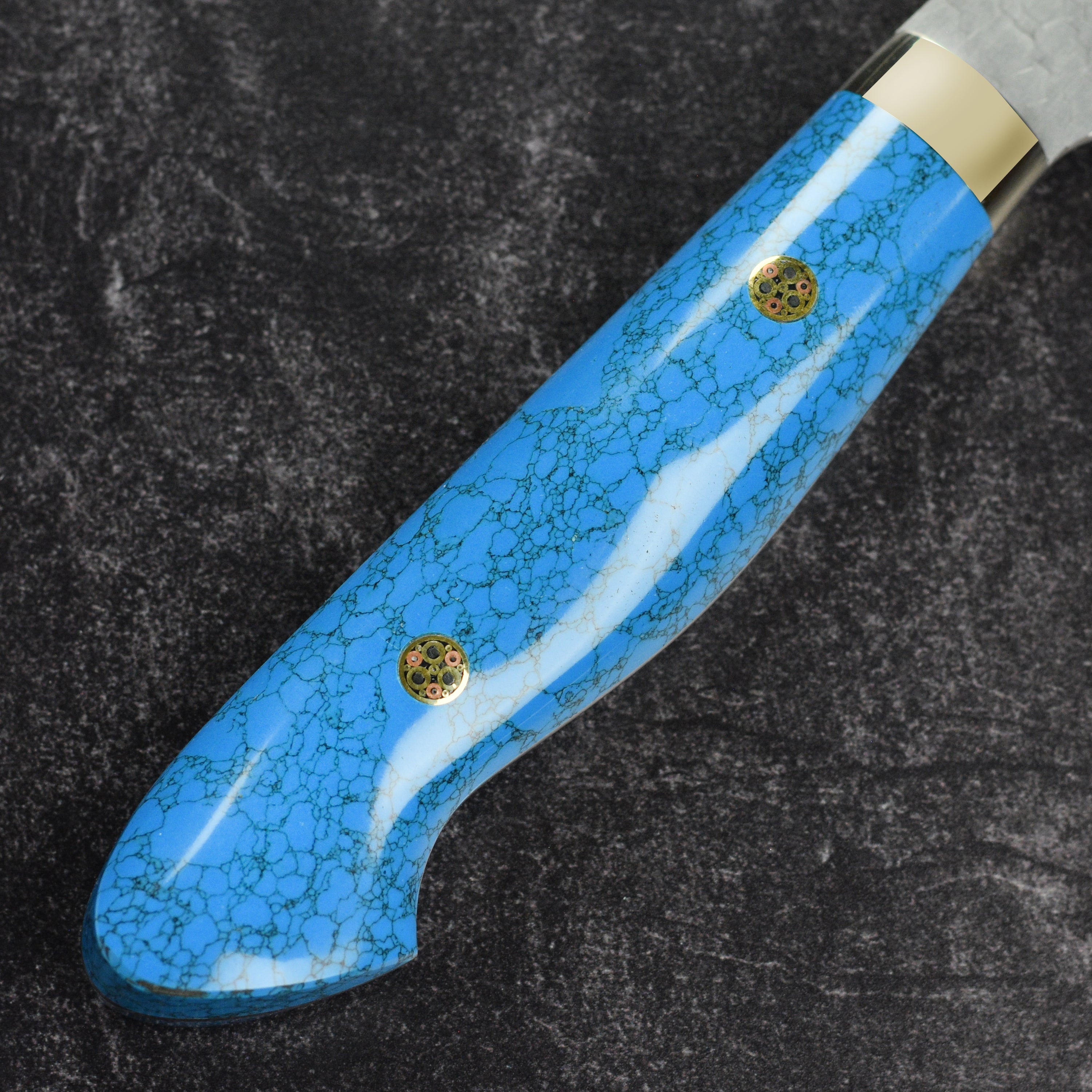 Side view of Nigara SG2 gyuto knife showing hammered tsuchime finish and blue turquoise handle