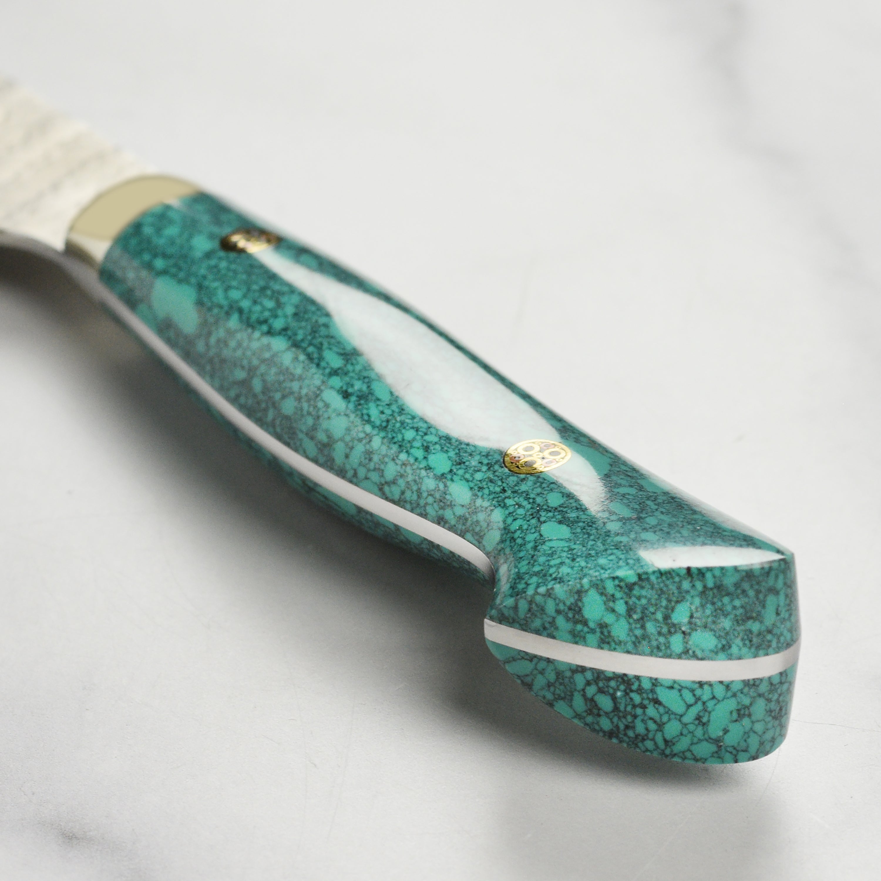 Japanese Nakiri knife with green turquoise handle on cutting board for kitchen prep