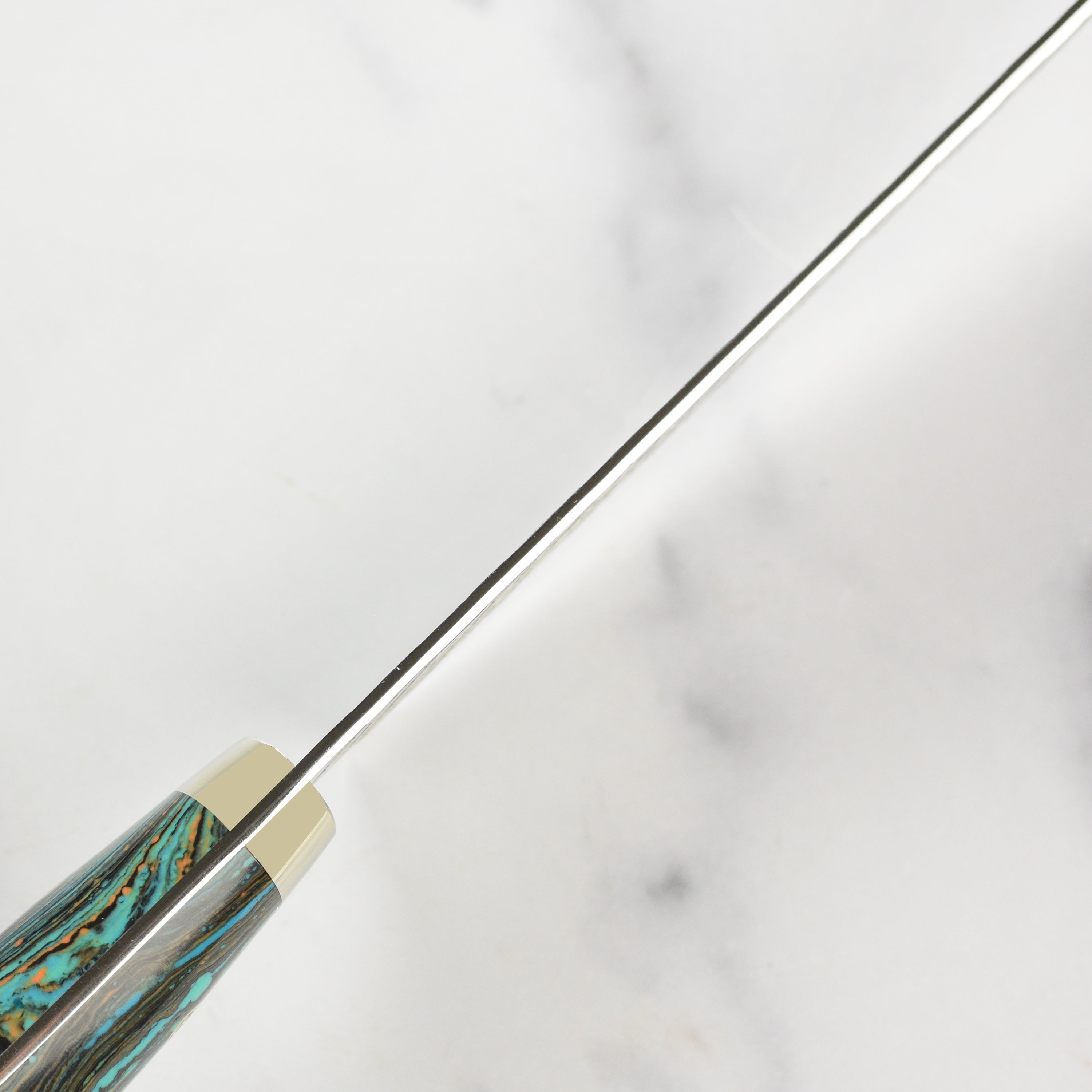 The ergonomic handle of the turquoise striped Nakiri knife, designed for comfort and control.