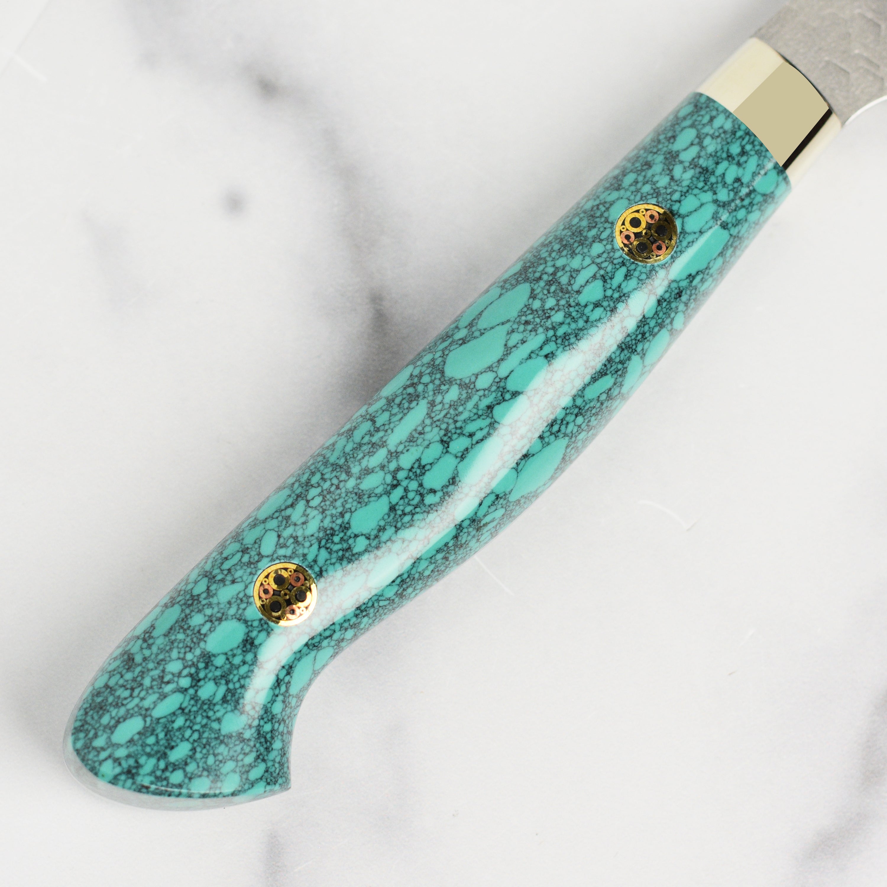 Close-up of the Nigara SG2 Kiritsuke petty knife showcasing the sharp blade and turquoise handle.