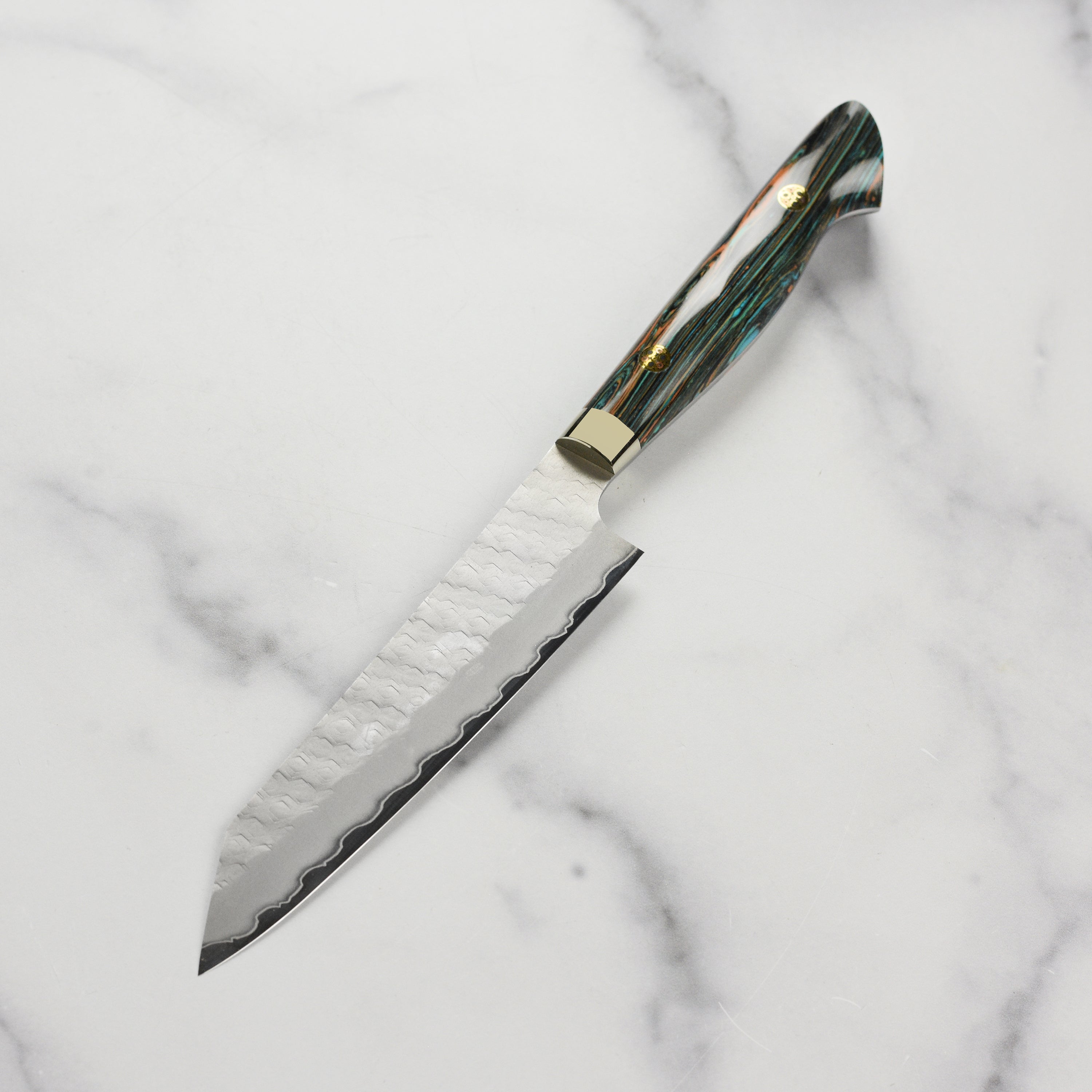 Nigara SG2 Kiritsuke chef knife in use, slicing vegetables with precision.