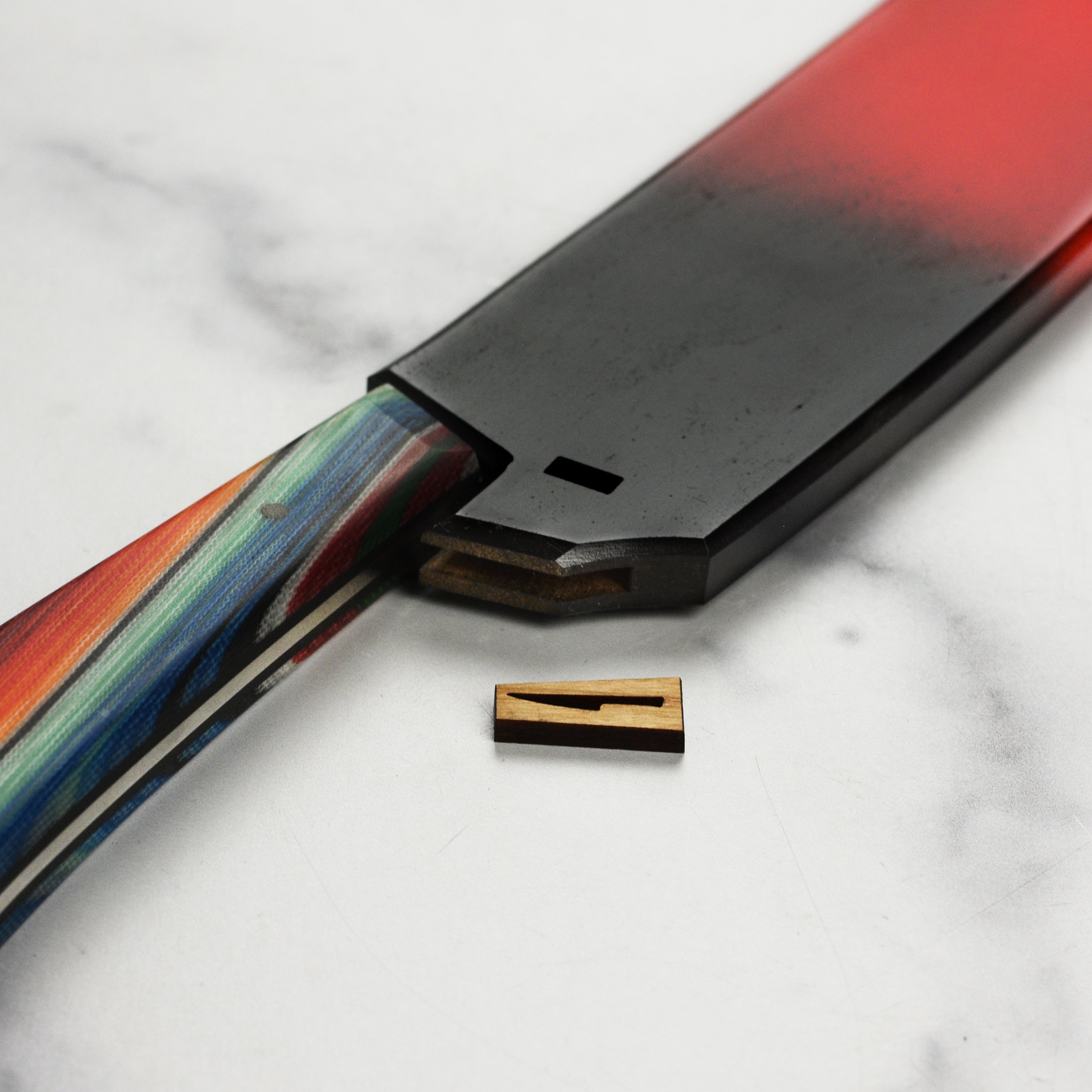 Full profile shot of the kitchen knife with Saya cover placed beside it on a cutting board