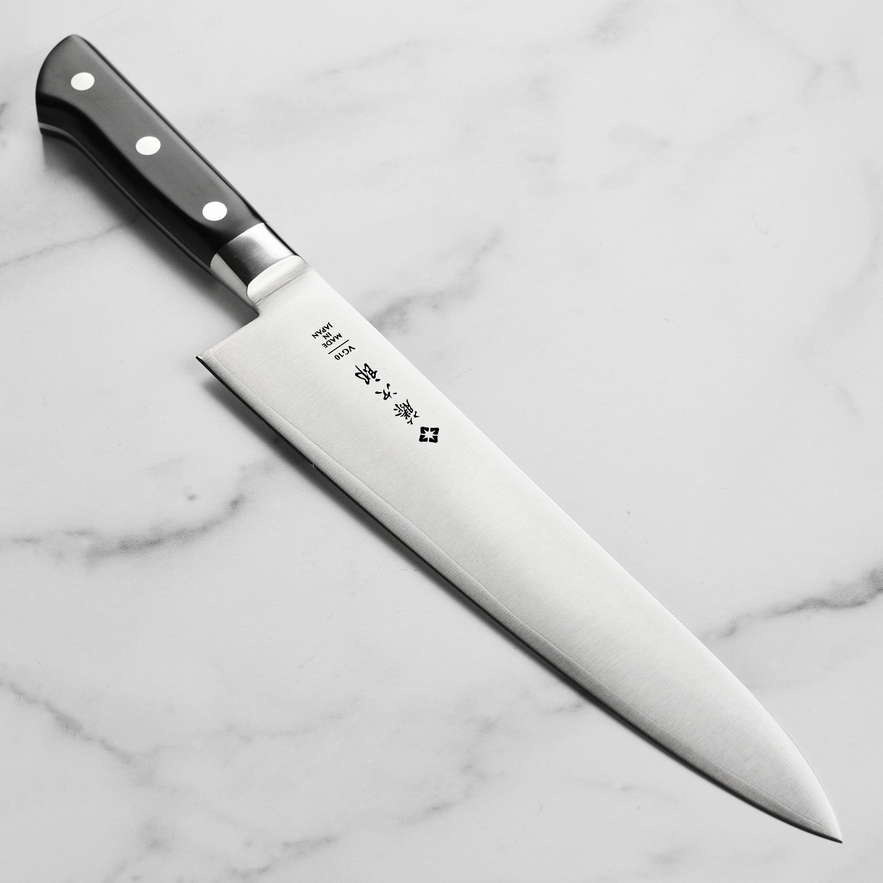 Close-up of the Japanese chef's knife blade showing sharp edge and full tang