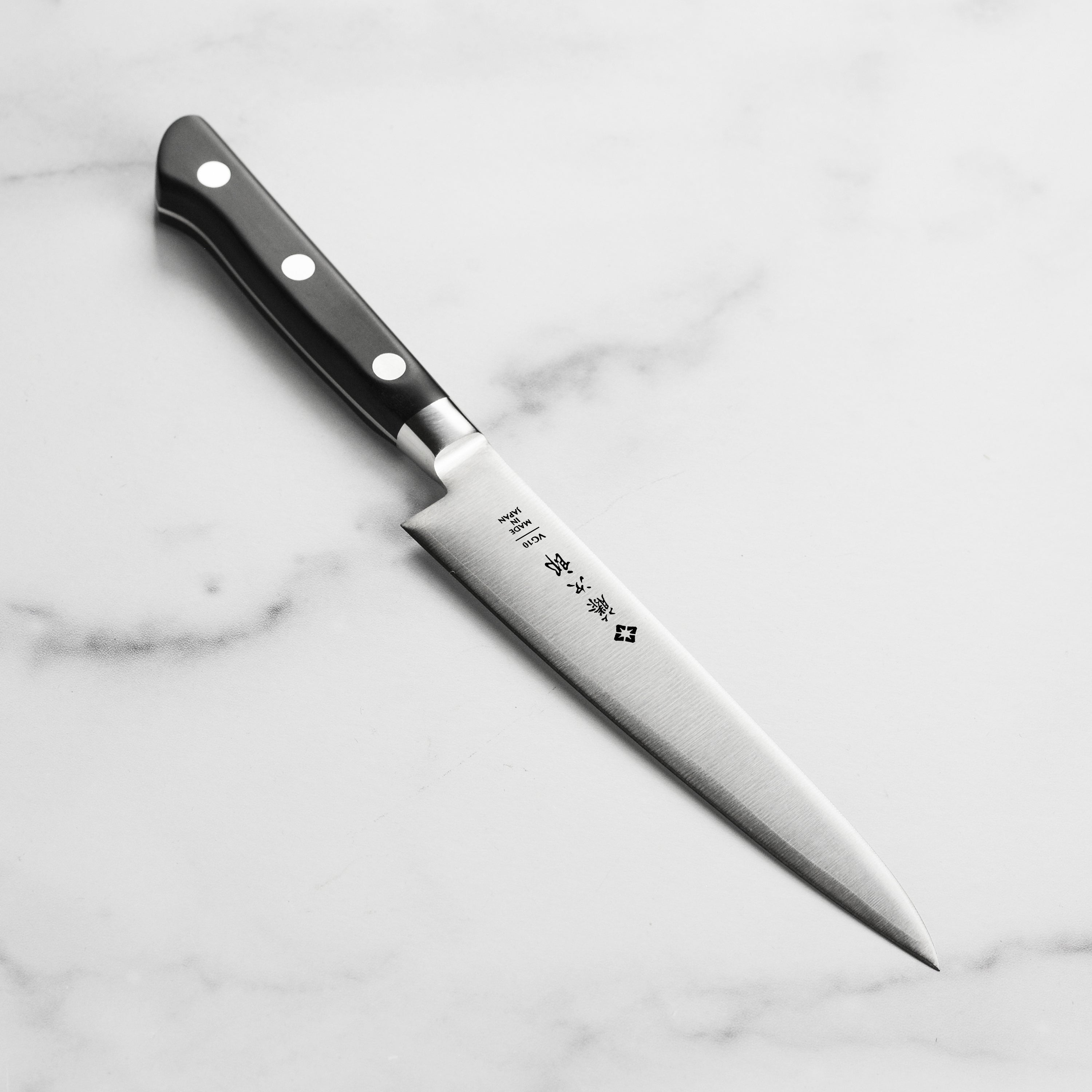Close-up of the Tojiro Classic 6-Inch Japanese Utility Knife blade, highlighting its sharpness and craftsmanship.