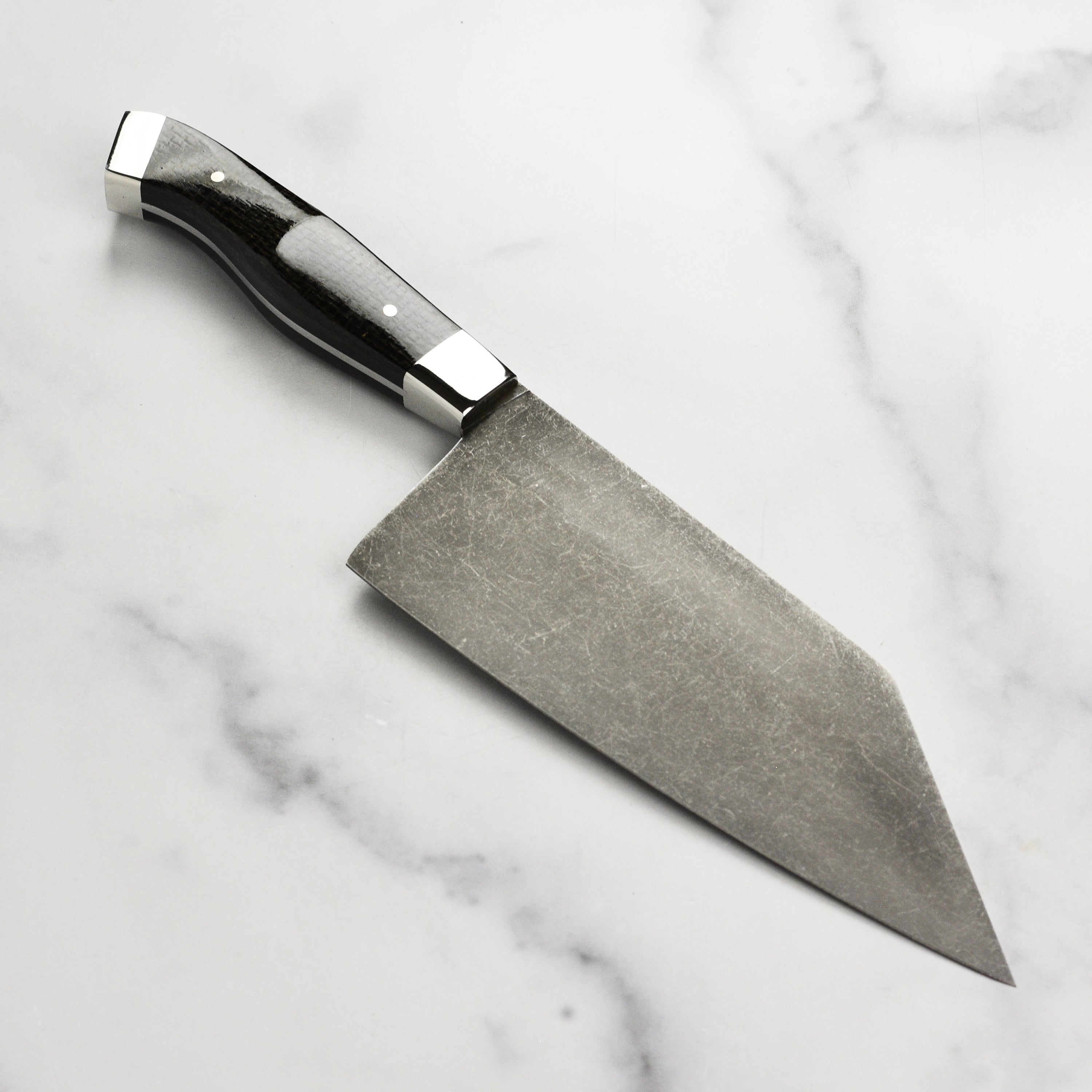 Reno Artisan chef knife positioned with fresh vegetables, highlighting its top-rated performance for home cooks.