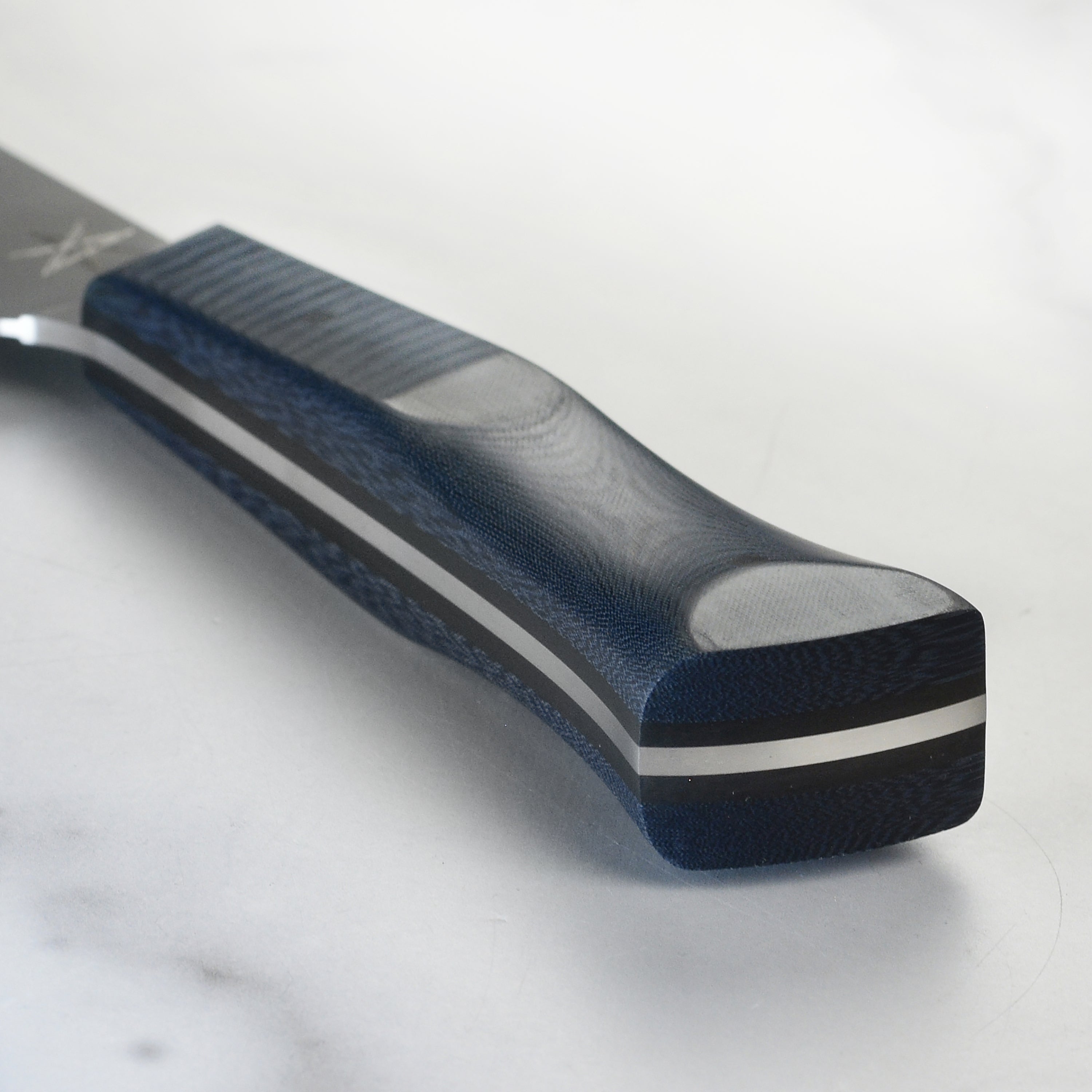 Close-up view of the blue linen micarta handle on the chef chopper knife.