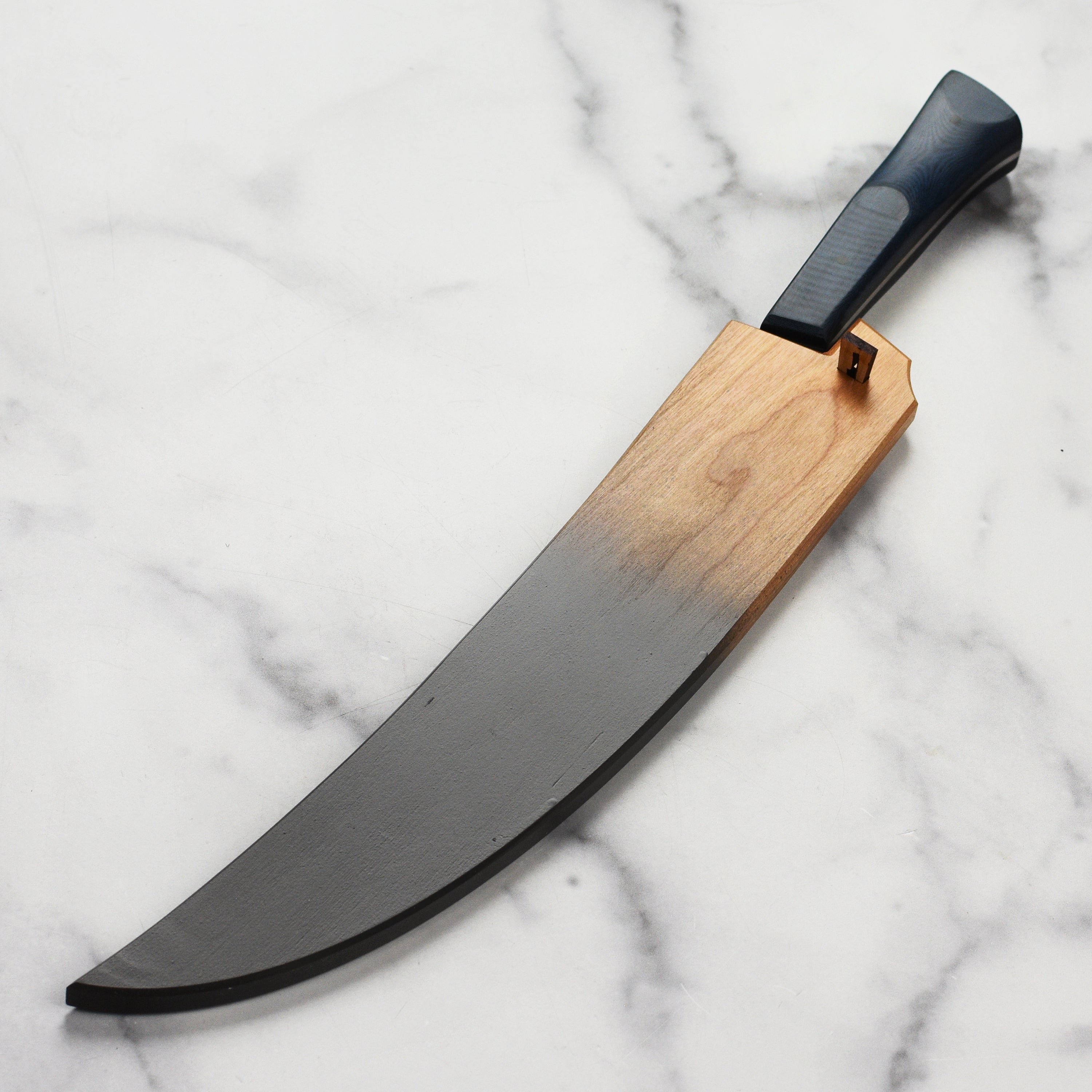 Side view of the handmade sheath with pins, highlighting cherry wood construction and sleek design.