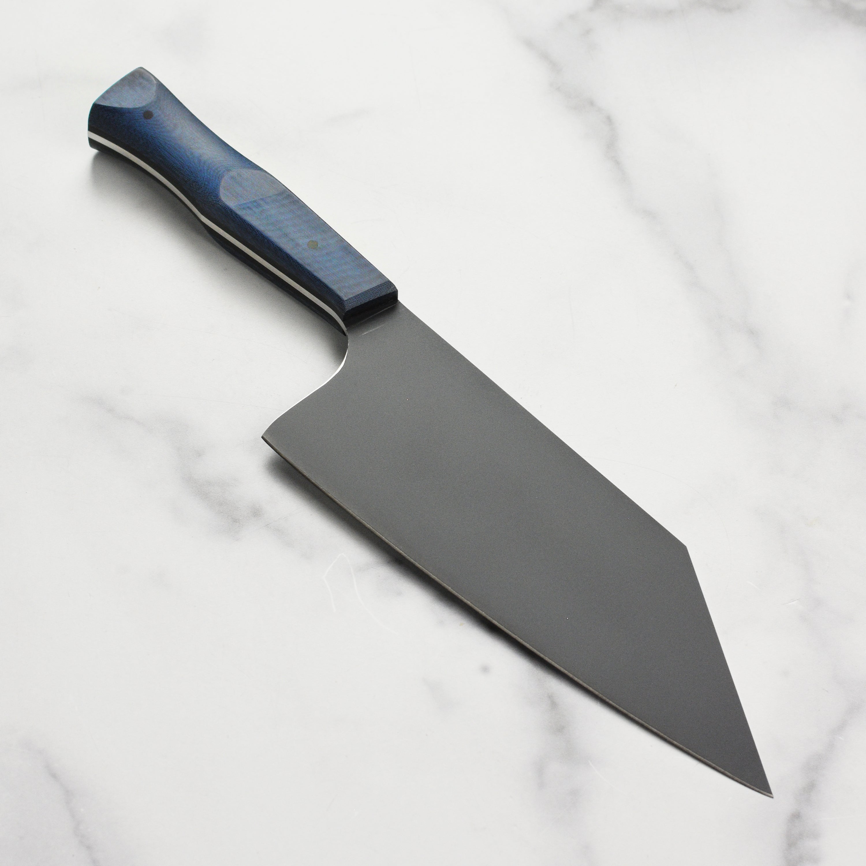 The Blue Micarta Chef Chopper Knife in action, chopping vegetables on a wooden cutting board.