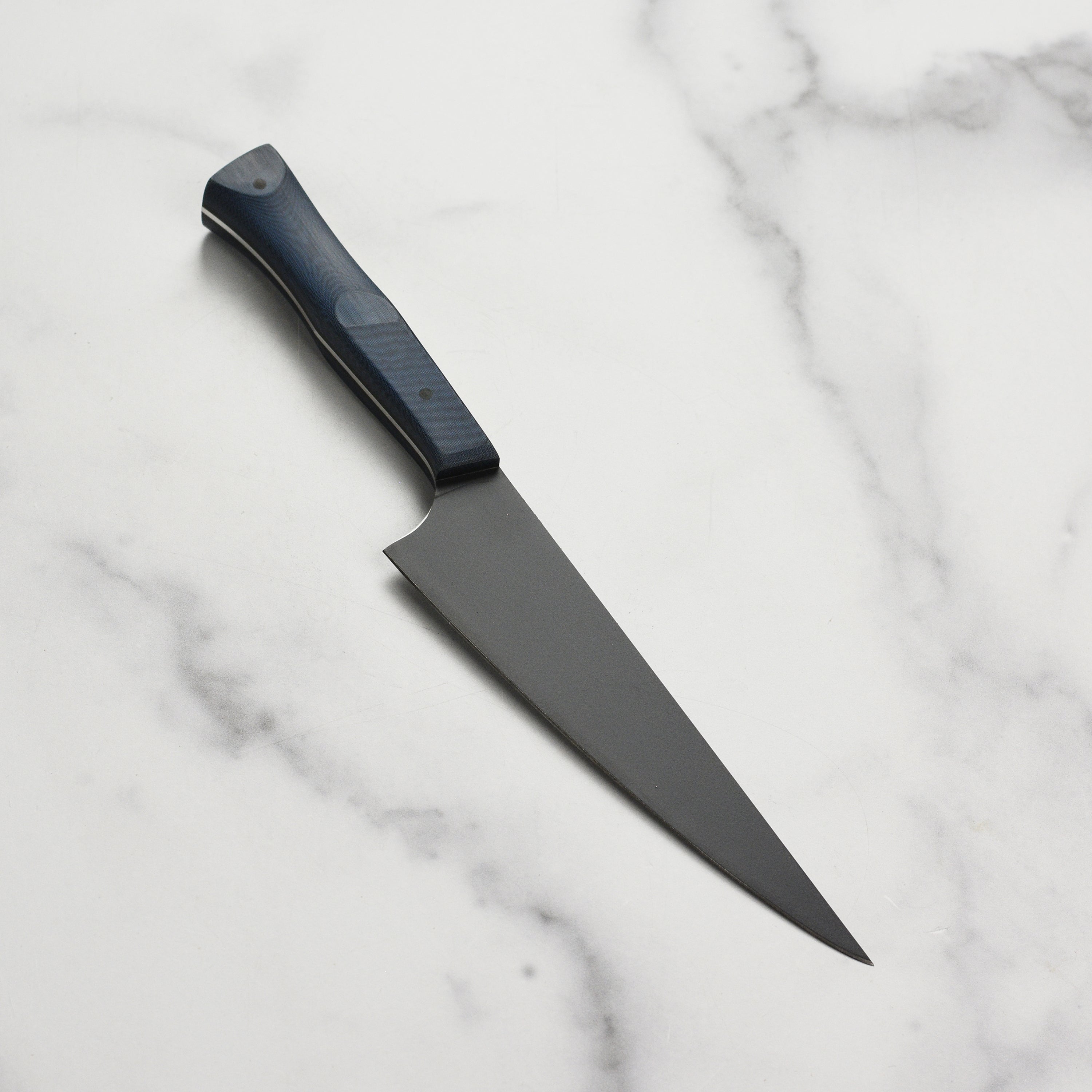 Side angle showing the blue linen micarta handle with black G-10 pins