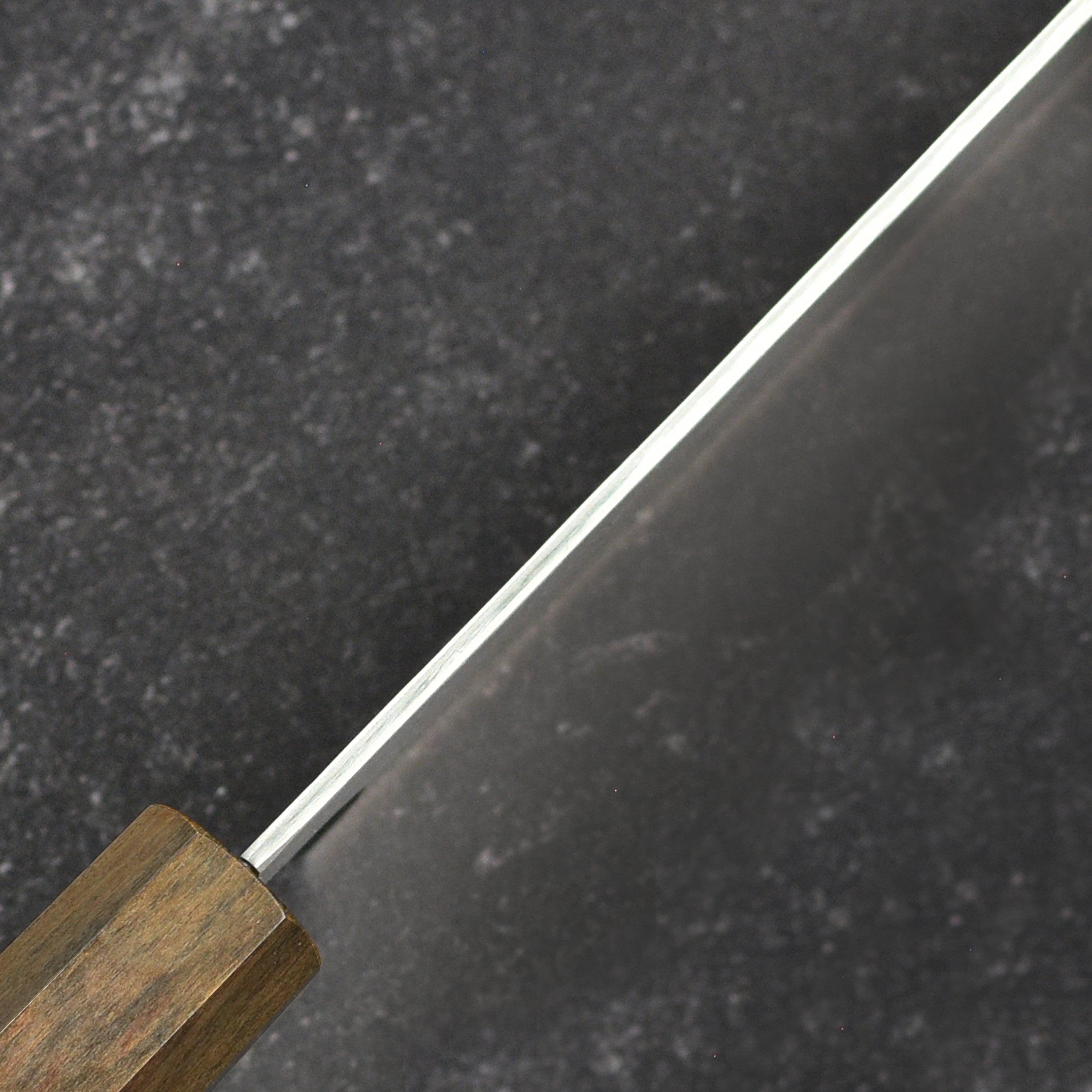 Close-up of the handle of the VG10 Tsuchime Damascus Nakiri knife, highlighting its ergonomic design.