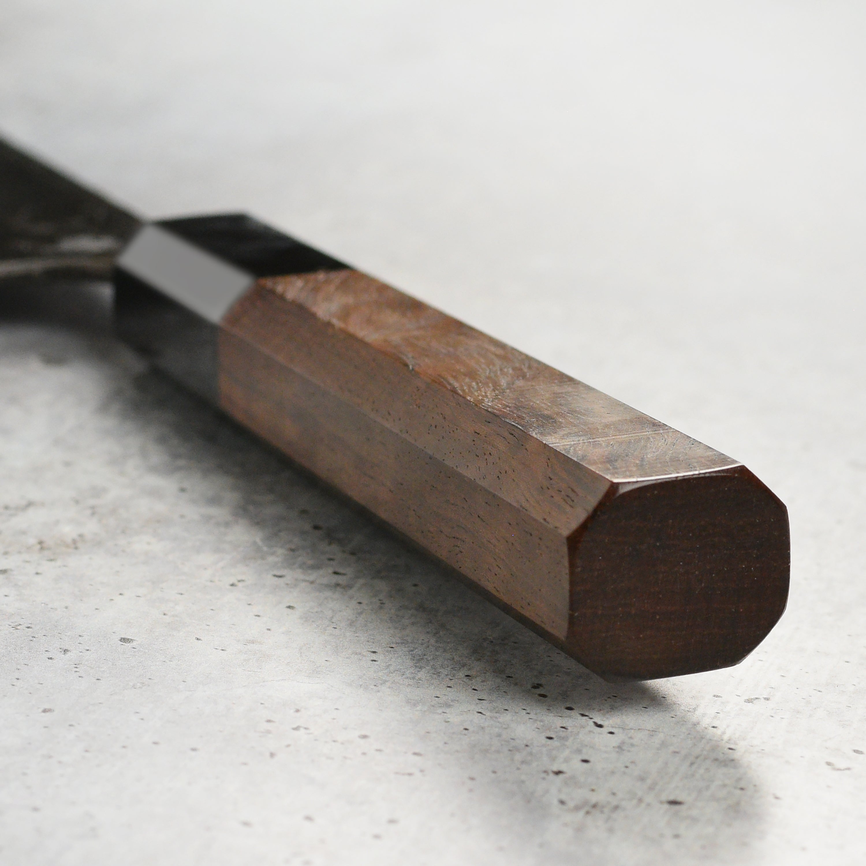 Japanese Nakiri knife in hand, highlighting kurouchi finish and blade details