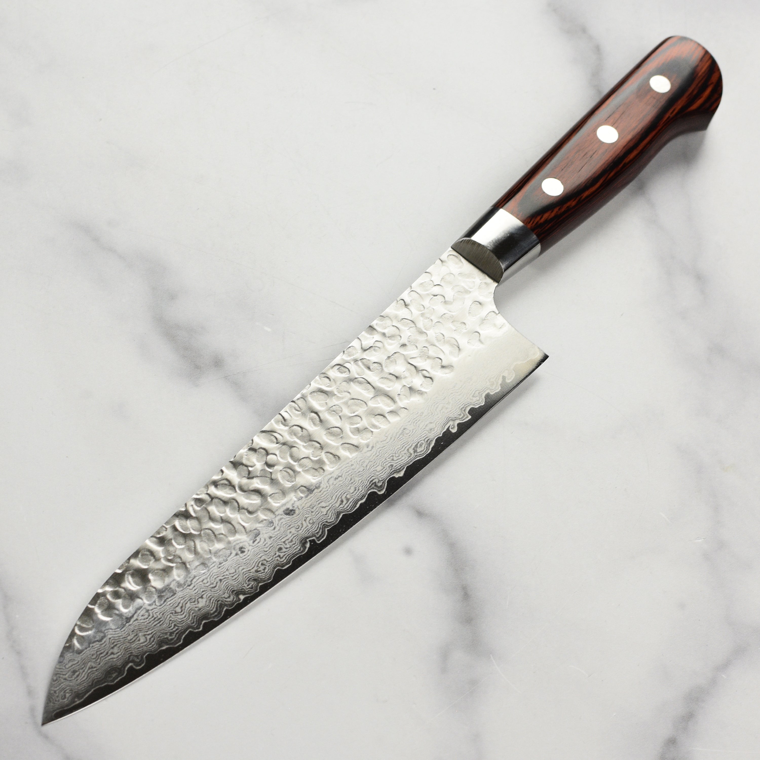 The gyuto knife in action, slicing through fresh vegetables with ease.