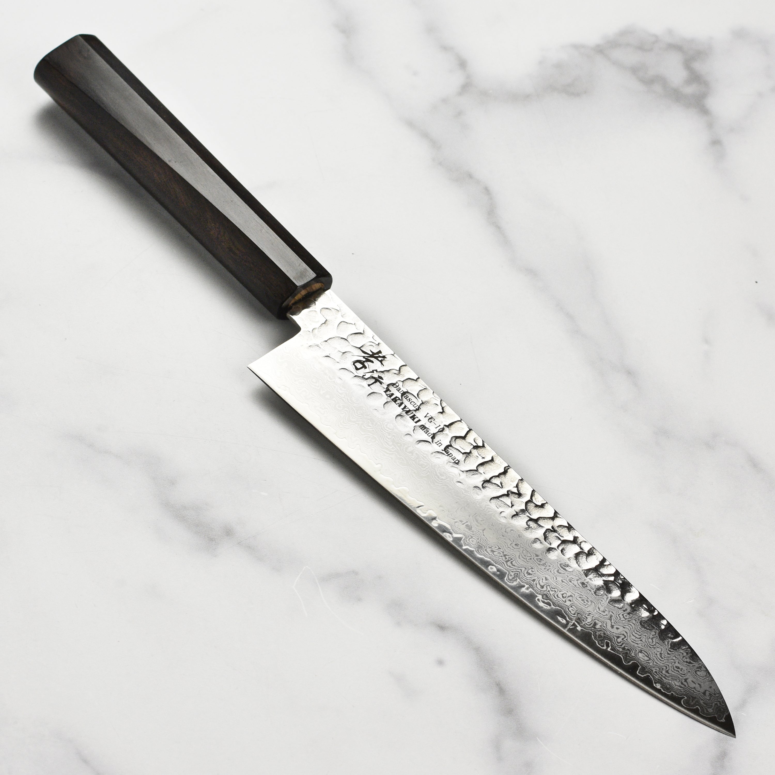 Front view of Takayuki Tsuchime Damascus Gyuto with ebony handle, highlighting craftsmanship and blade design