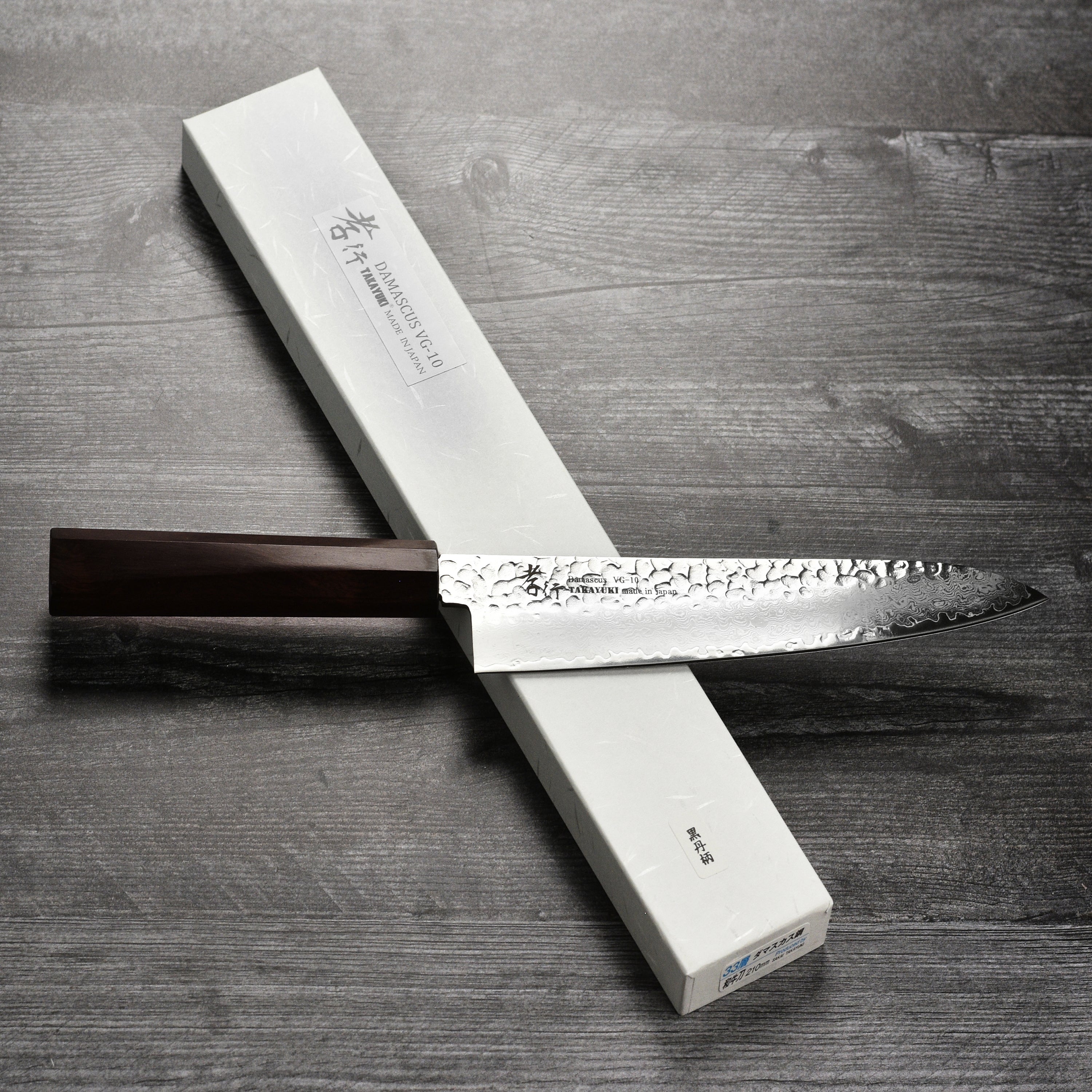 Front view of Takayuki Tsuchime Damascus Gyuto with ebony handle, highlighting craftsmanship and blade design