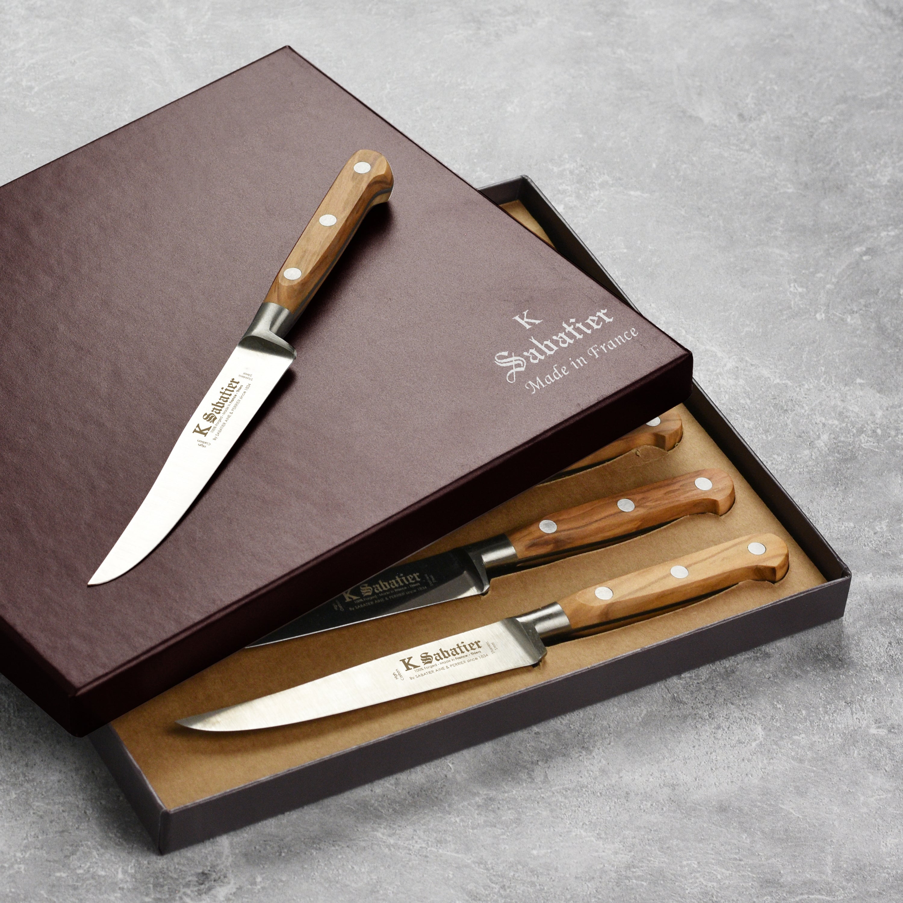 Display of the full 6-piece K Sabatier olive wood steak knife set on a modern kitchen counter