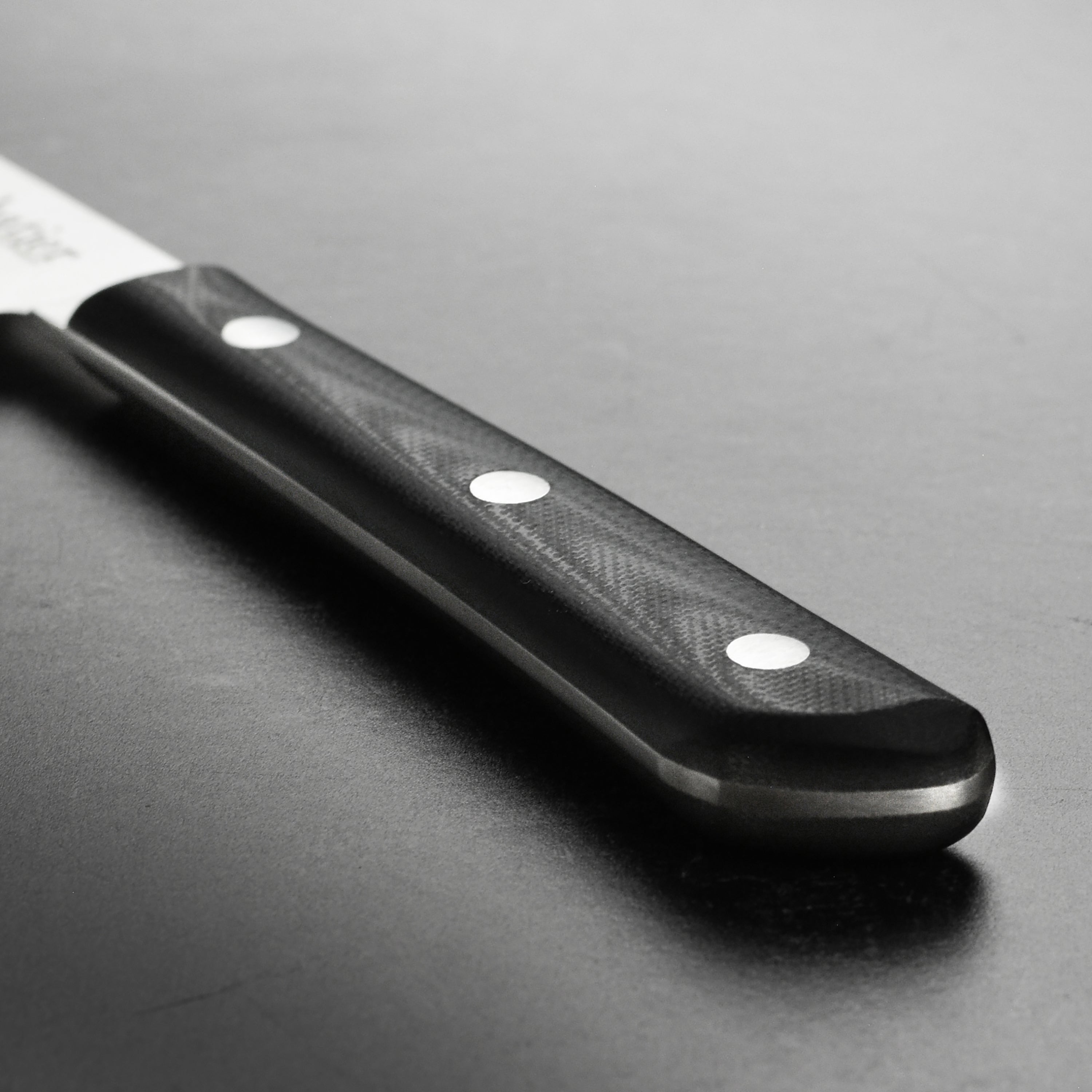 Detailed view of the 4-inch paring knife with G10 handle and polished edge