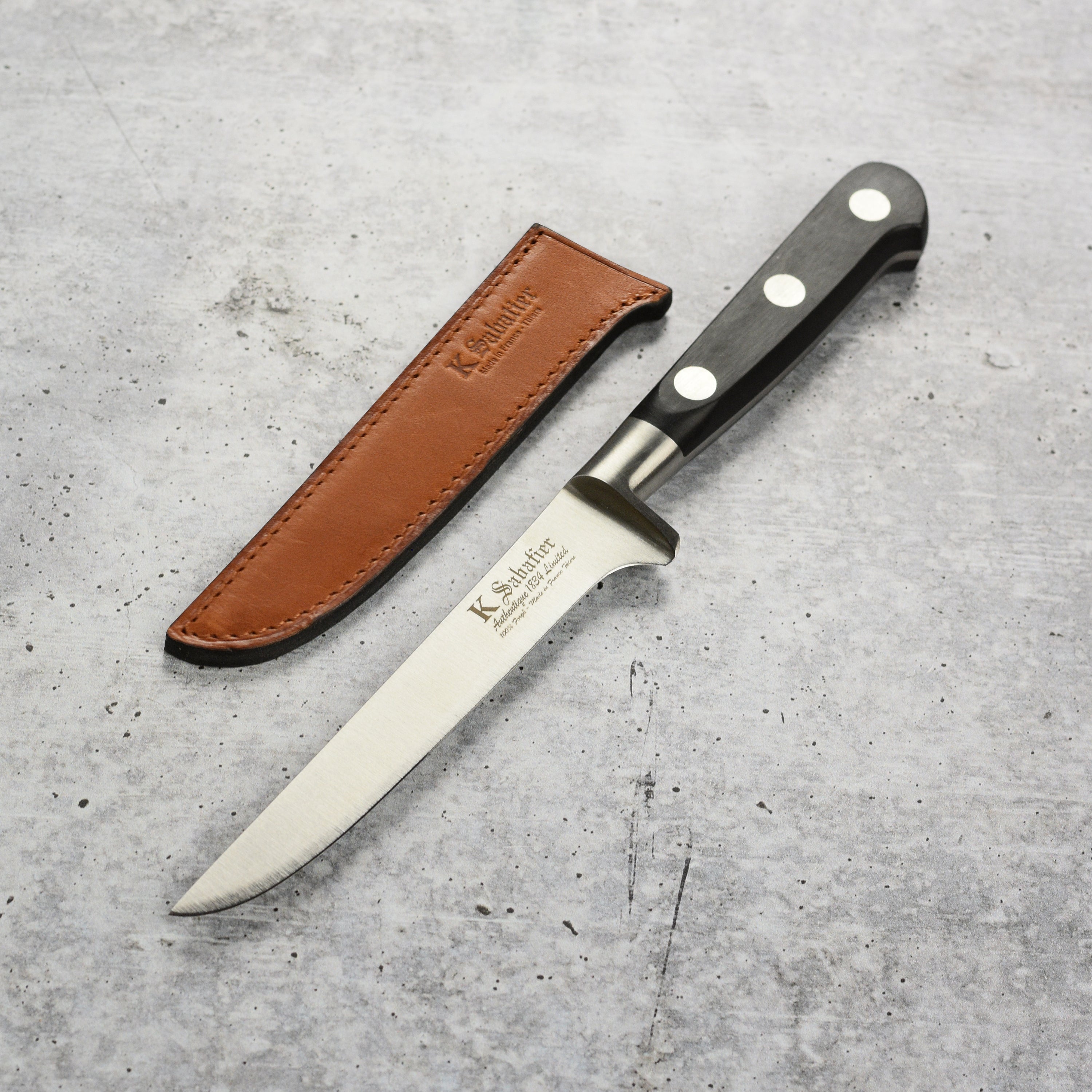 Close-up of the K Sabatier boning knife blade showing polished stainless steel and full-tang design