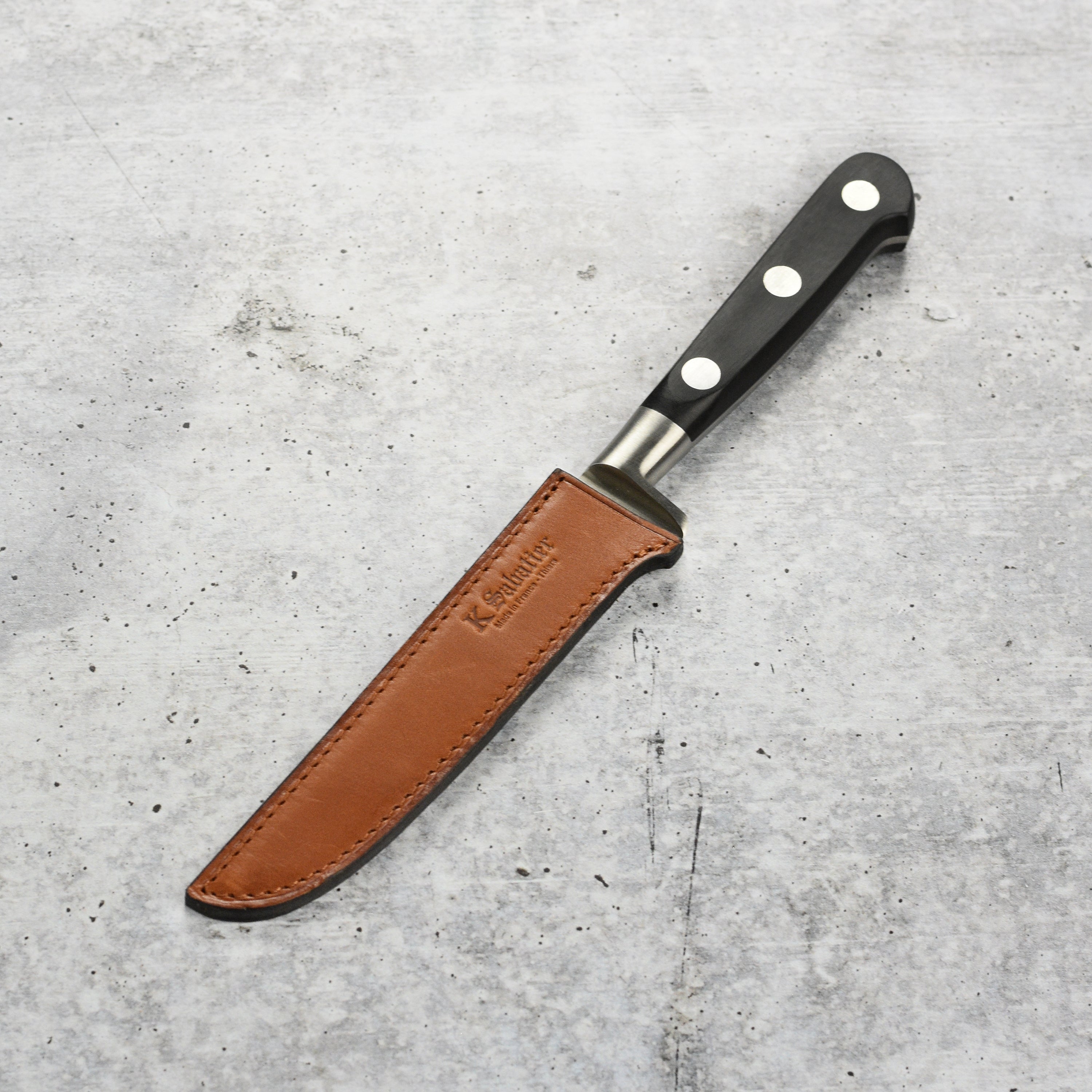 Close-up of the K Sabatier boning knife blade showing polished stainless steel and full-tang design