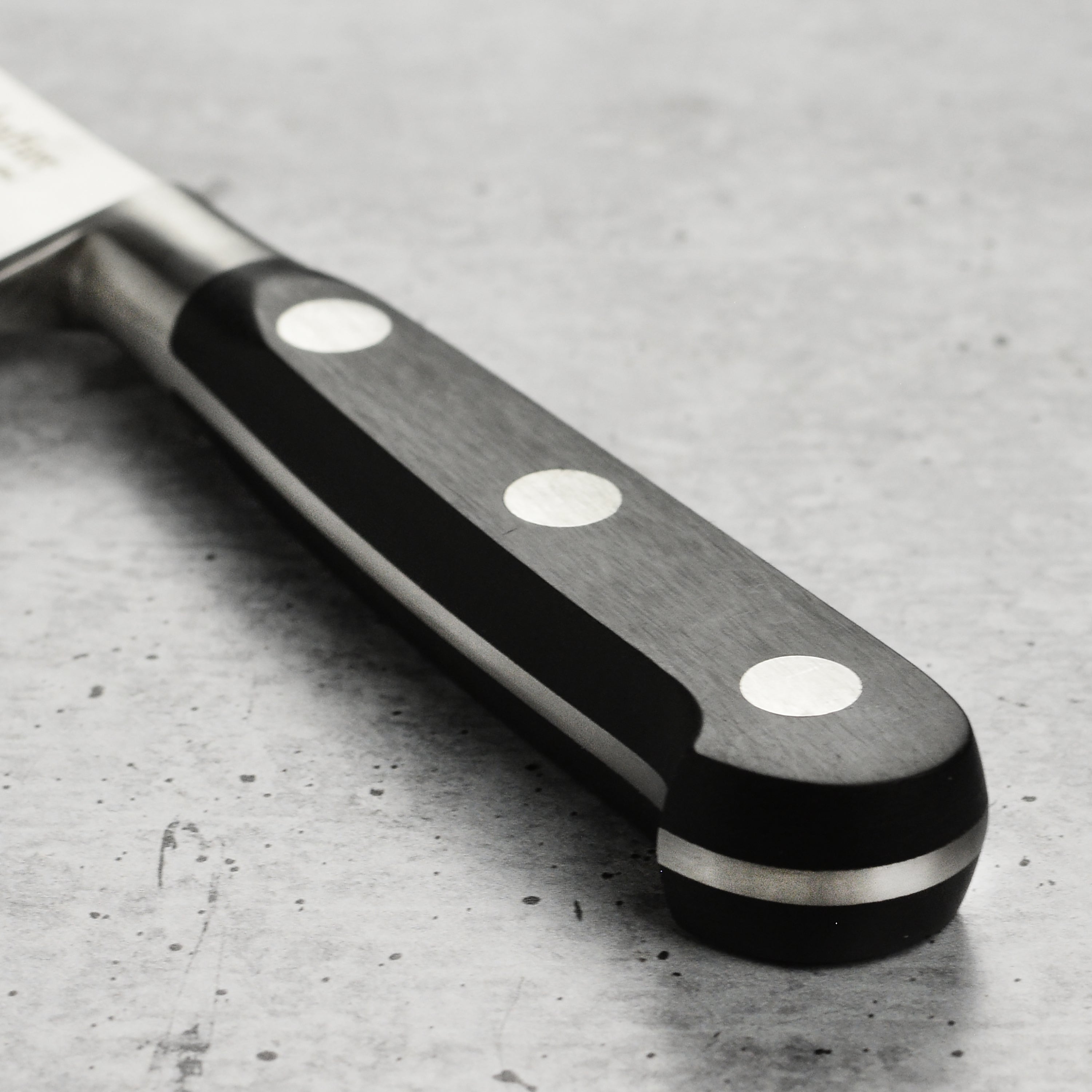 Side view of the kitchen knife with ergonomic POM handle and classic French bolster