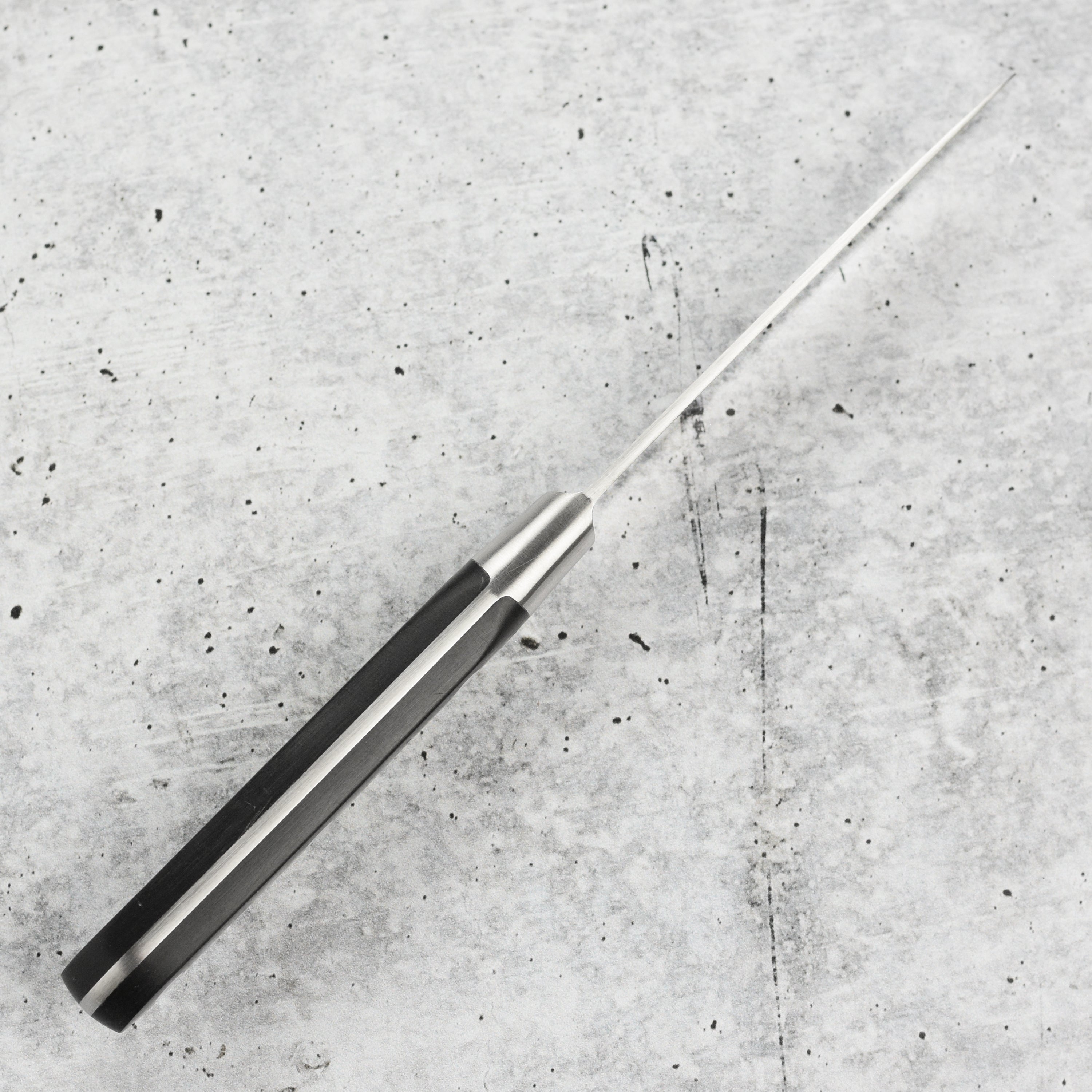 Elegant display of K Sabatier 4" paring knife with brown leather sheath on a rustic kitchen countertop.