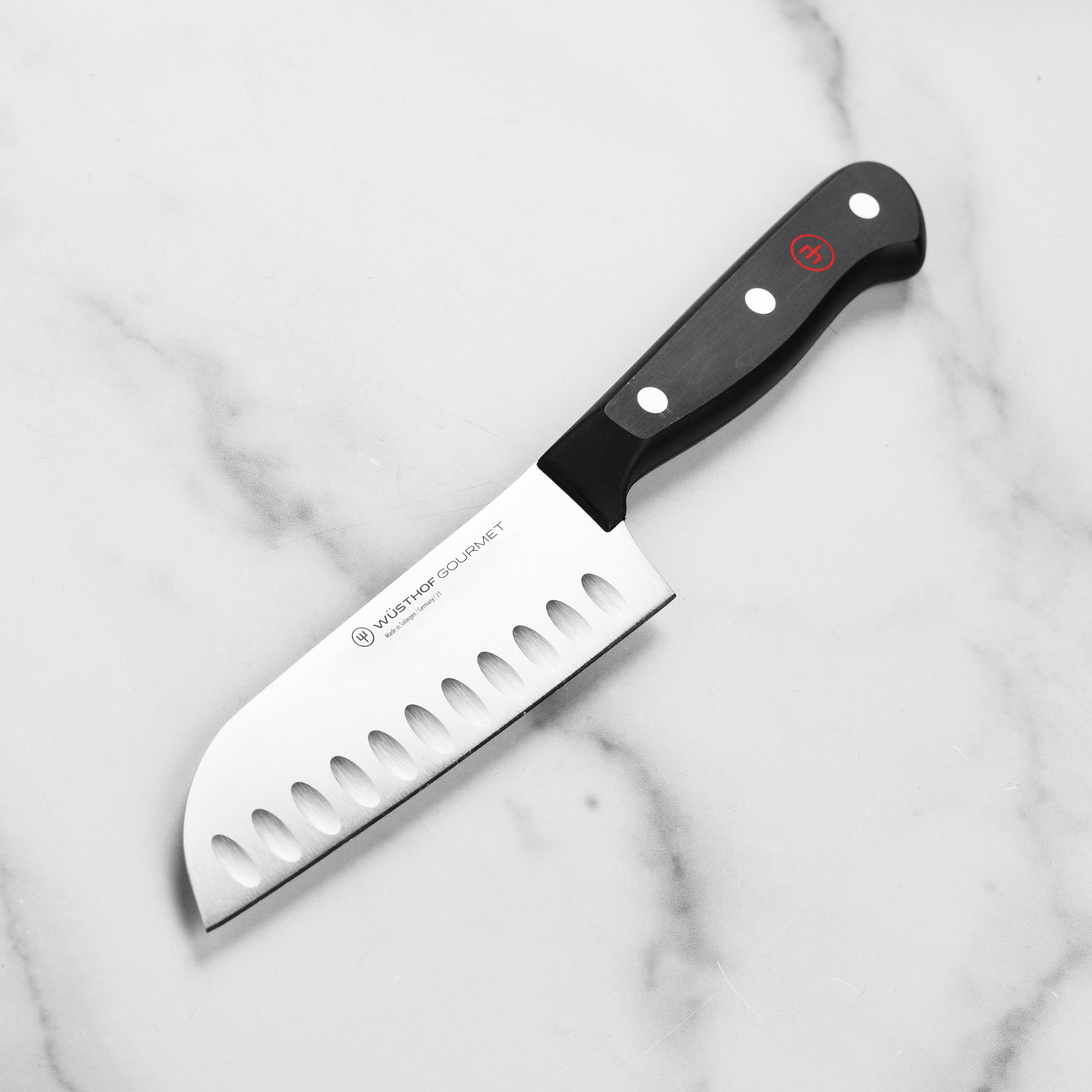 Close-up of Wusthof Gourmet 5-Inch Hollow Edge Santoku Knife showing the sharp blade and handle.