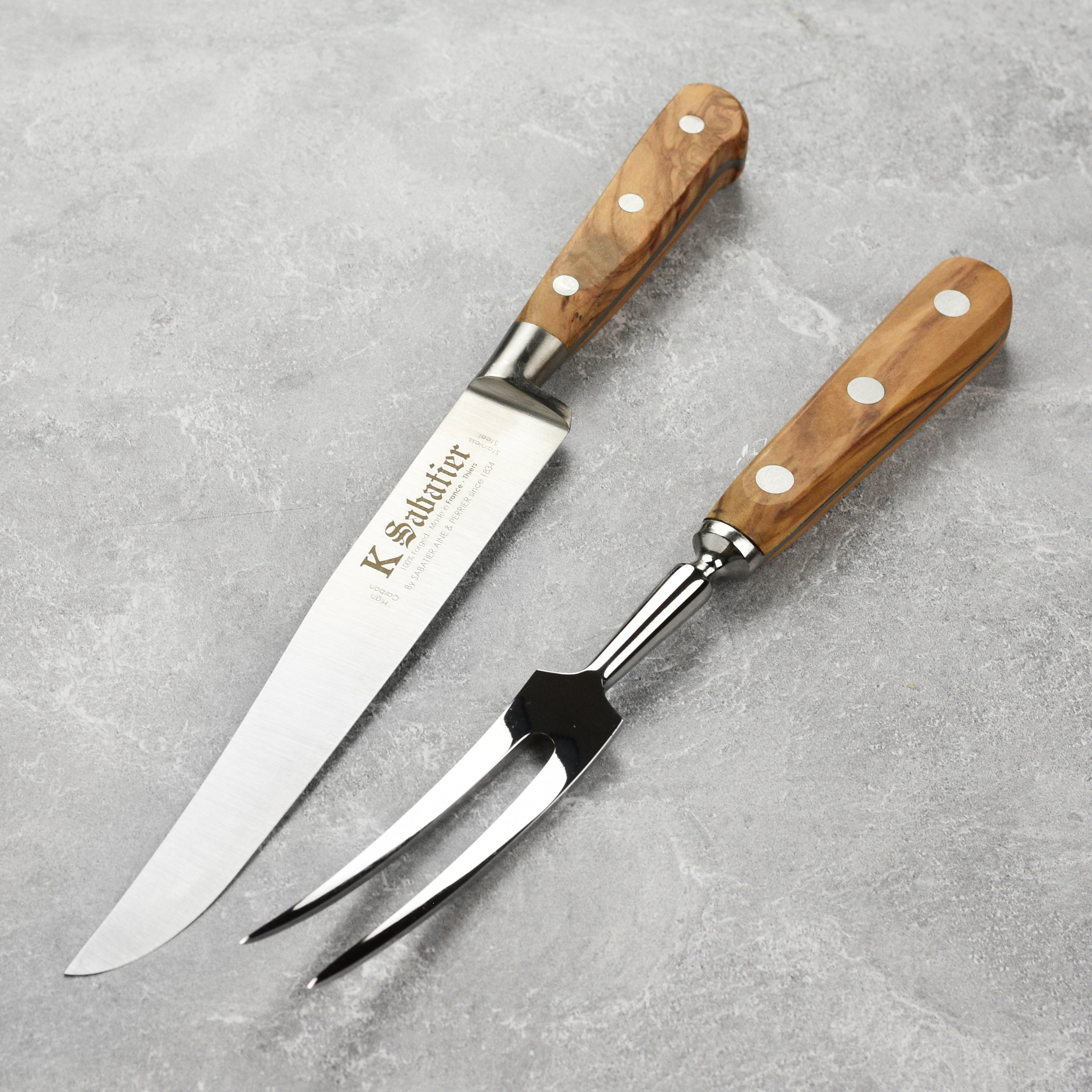 Close-up of the artisan olive wood carving knife showing the stainless steel blade and olive wood handle.