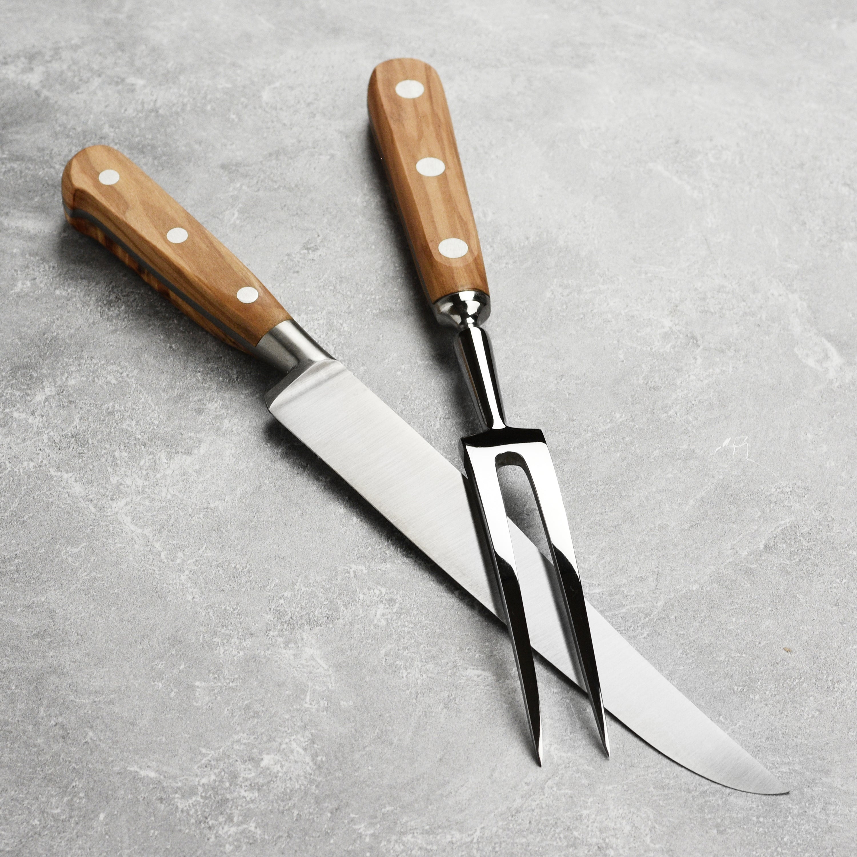 Close-up of the artisan olive wood carving knife showing the stainless steel blade and olive wood handle.