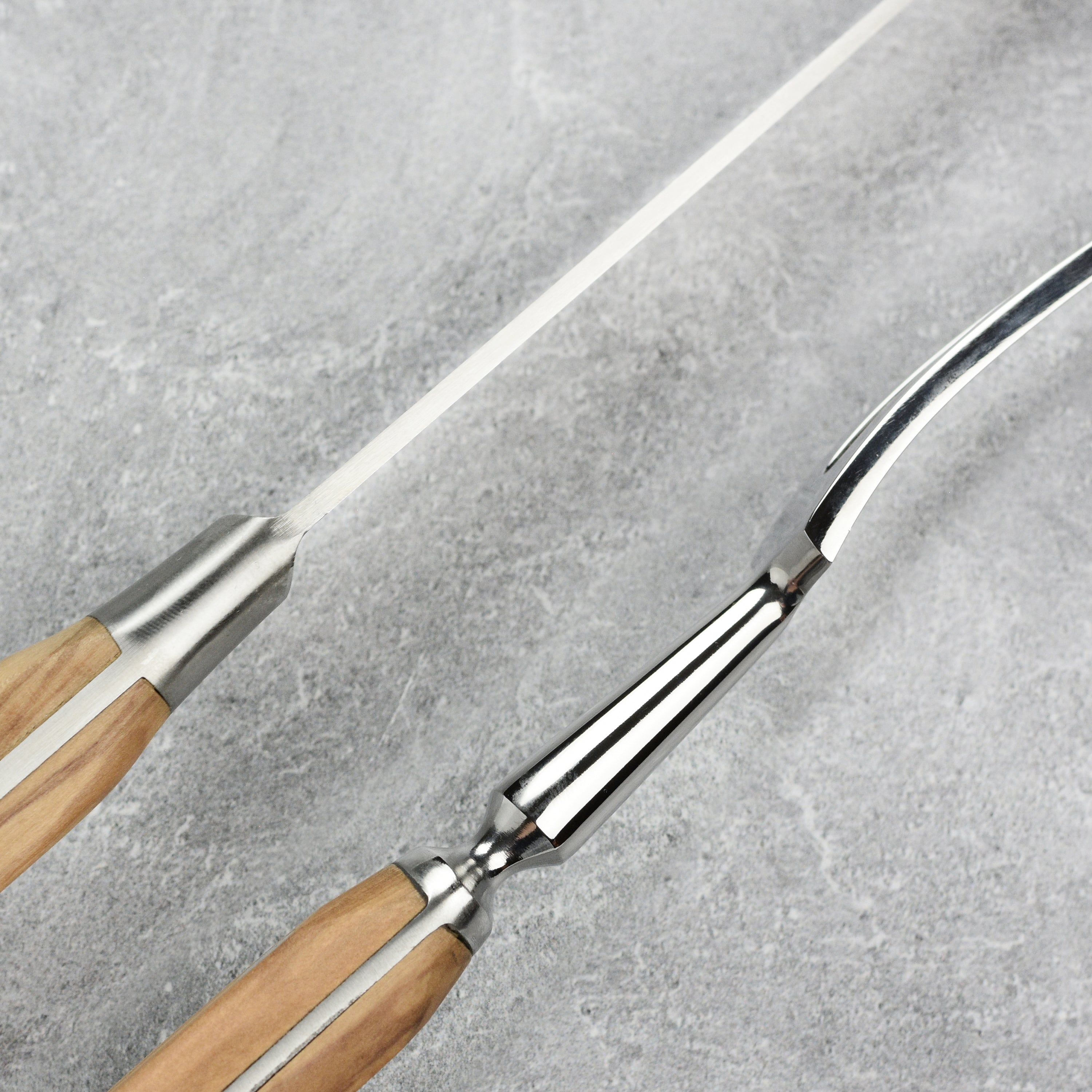 Artisan olive wood carving knife in action, expertly slicing a roast on a kitchen counter.