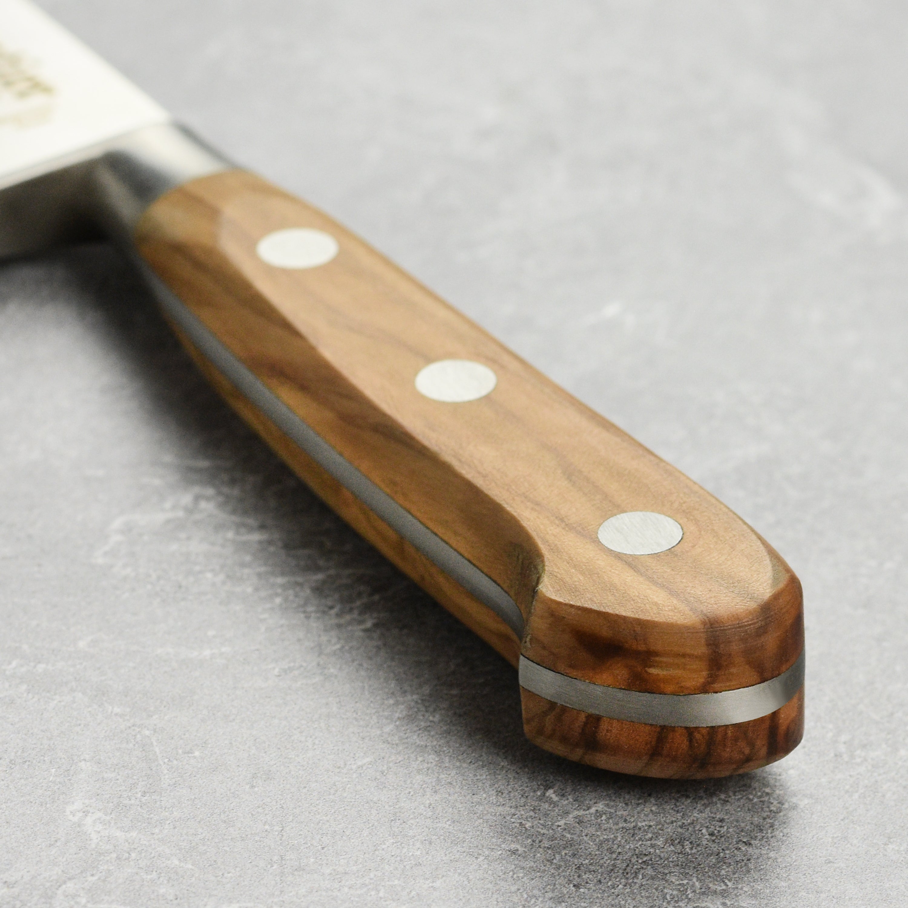 Close-up of the stainless blade and handcrafted olive wood handle