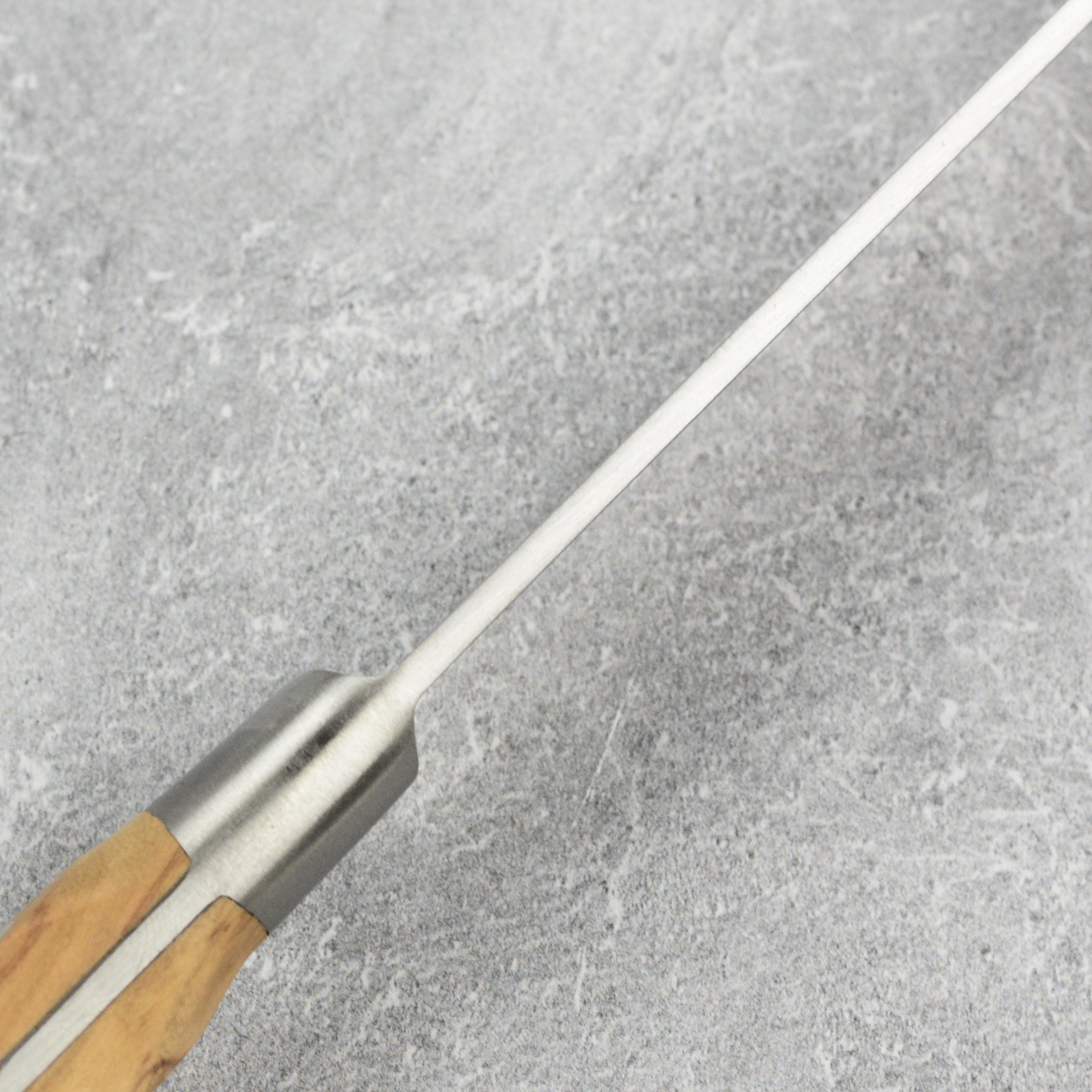 K Sabatier olive wood slicing knife displayed in a kitchen setting, demonstrating its use for cutting meats.