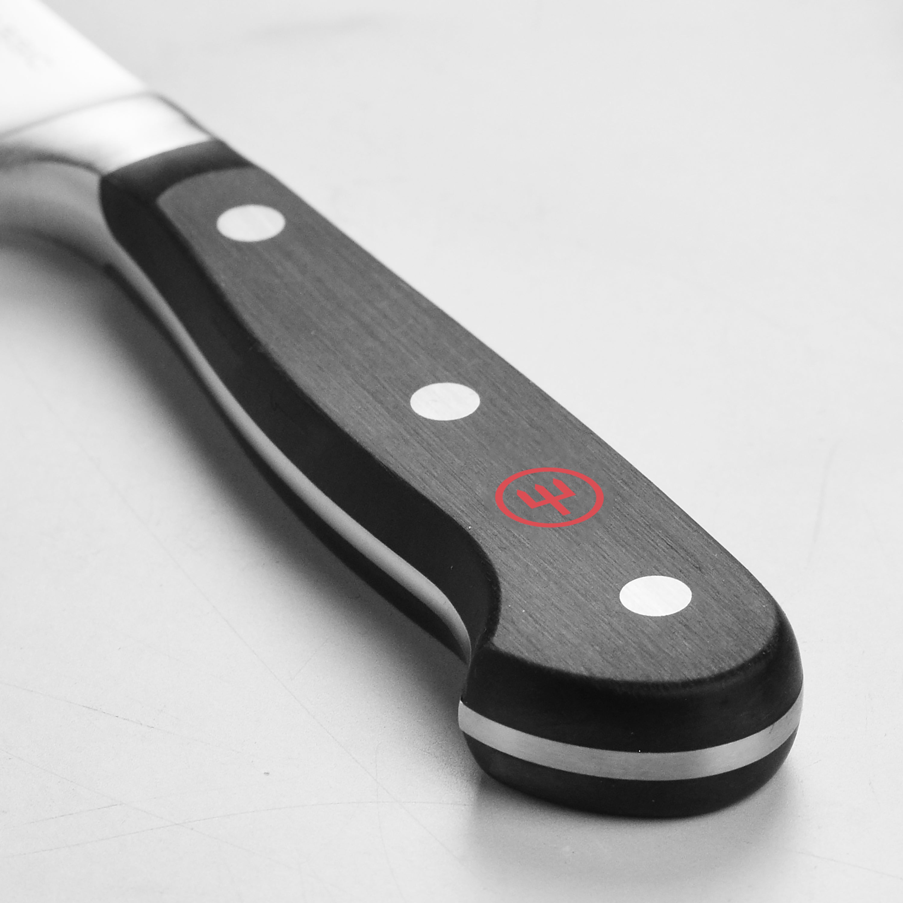 Wusthof boning knife in action, skillfully deboning meat on a cutting board.