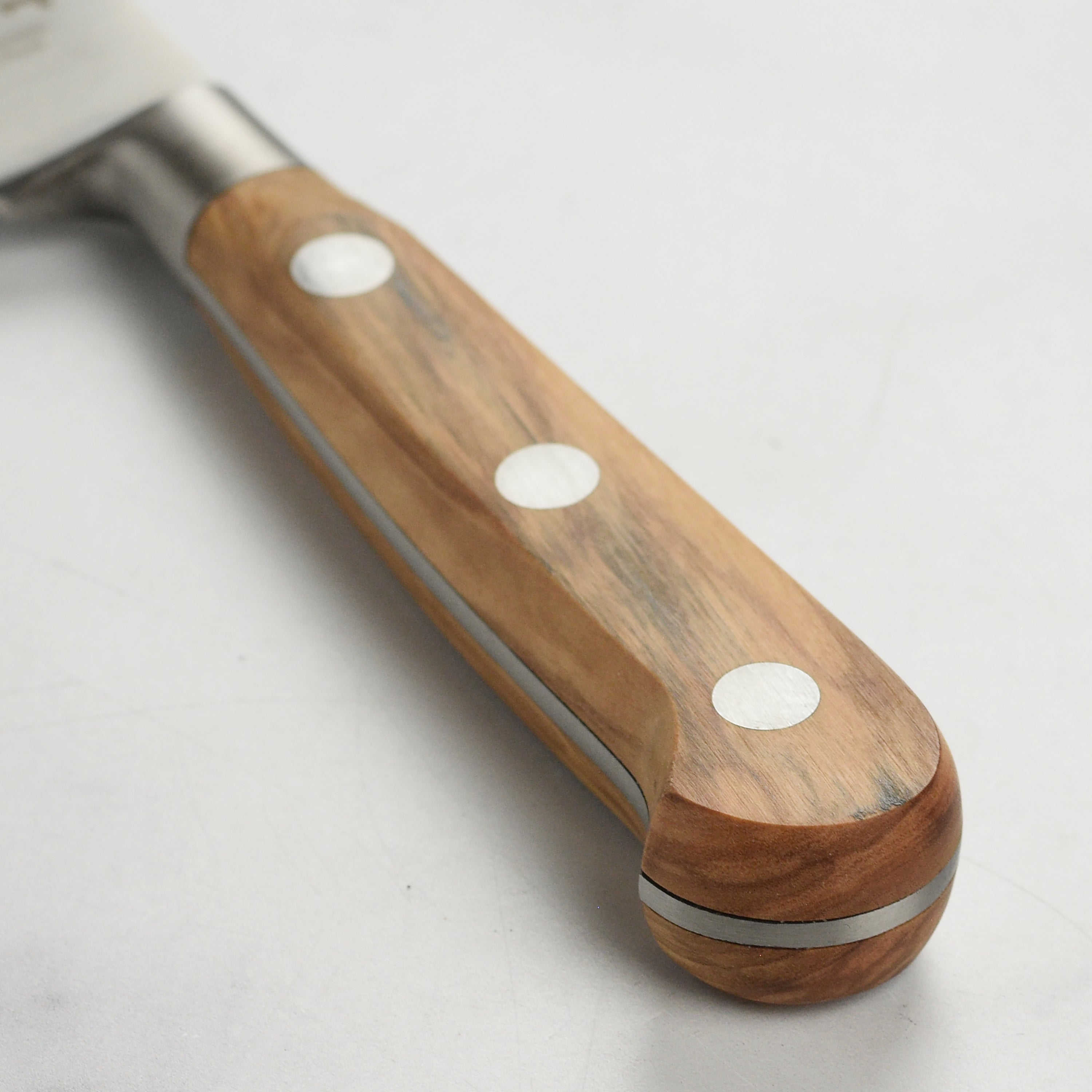 Olive wood knife displayed on a rustic wooden table, ideal for slicing freshly baked bread.